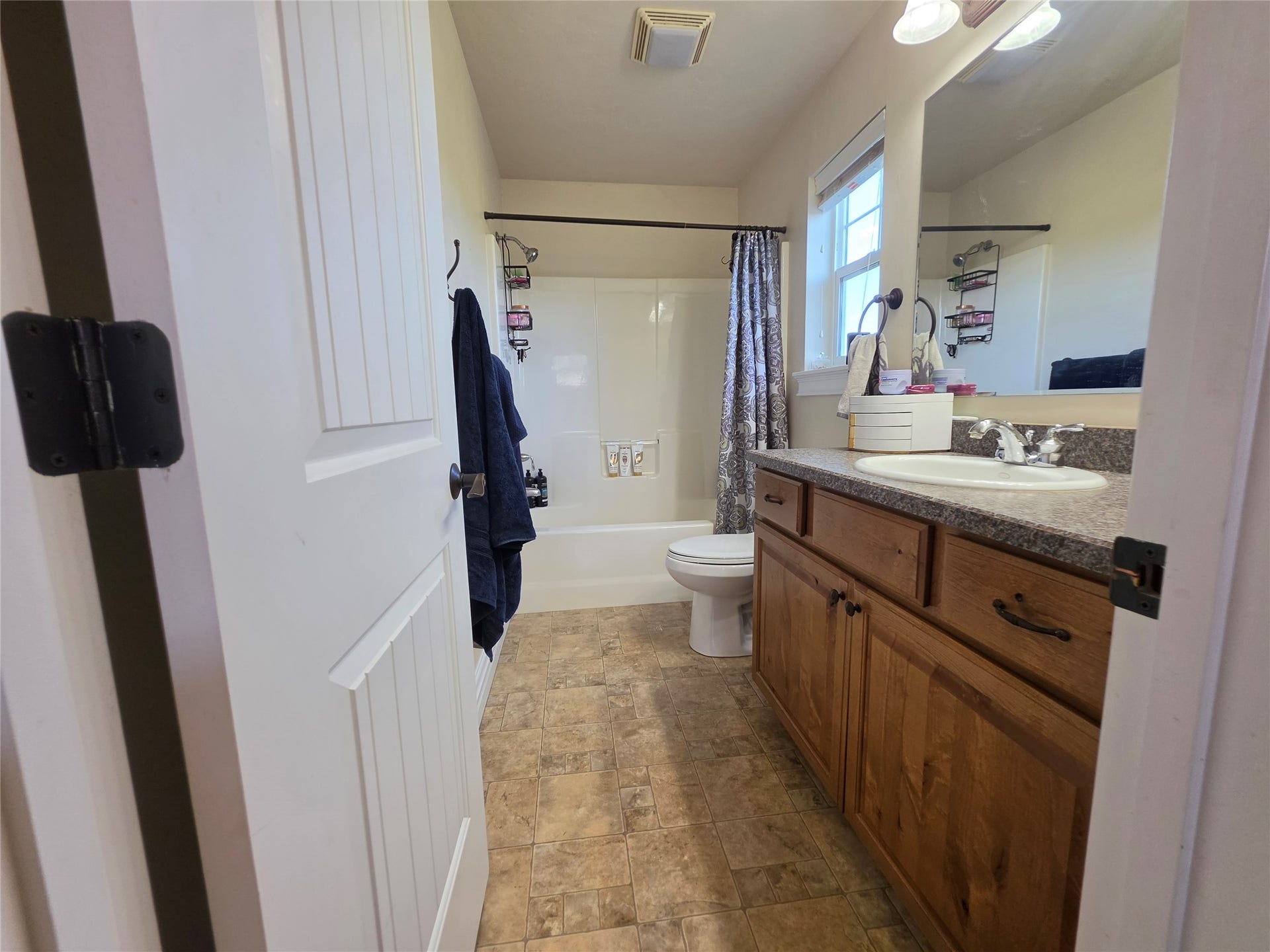 585 Wildflower Circle, Hamilton, MT 59840 Bathroom featuring a vanity with a surface-mount sink, wood-finish cabinetry, and a framed mirror