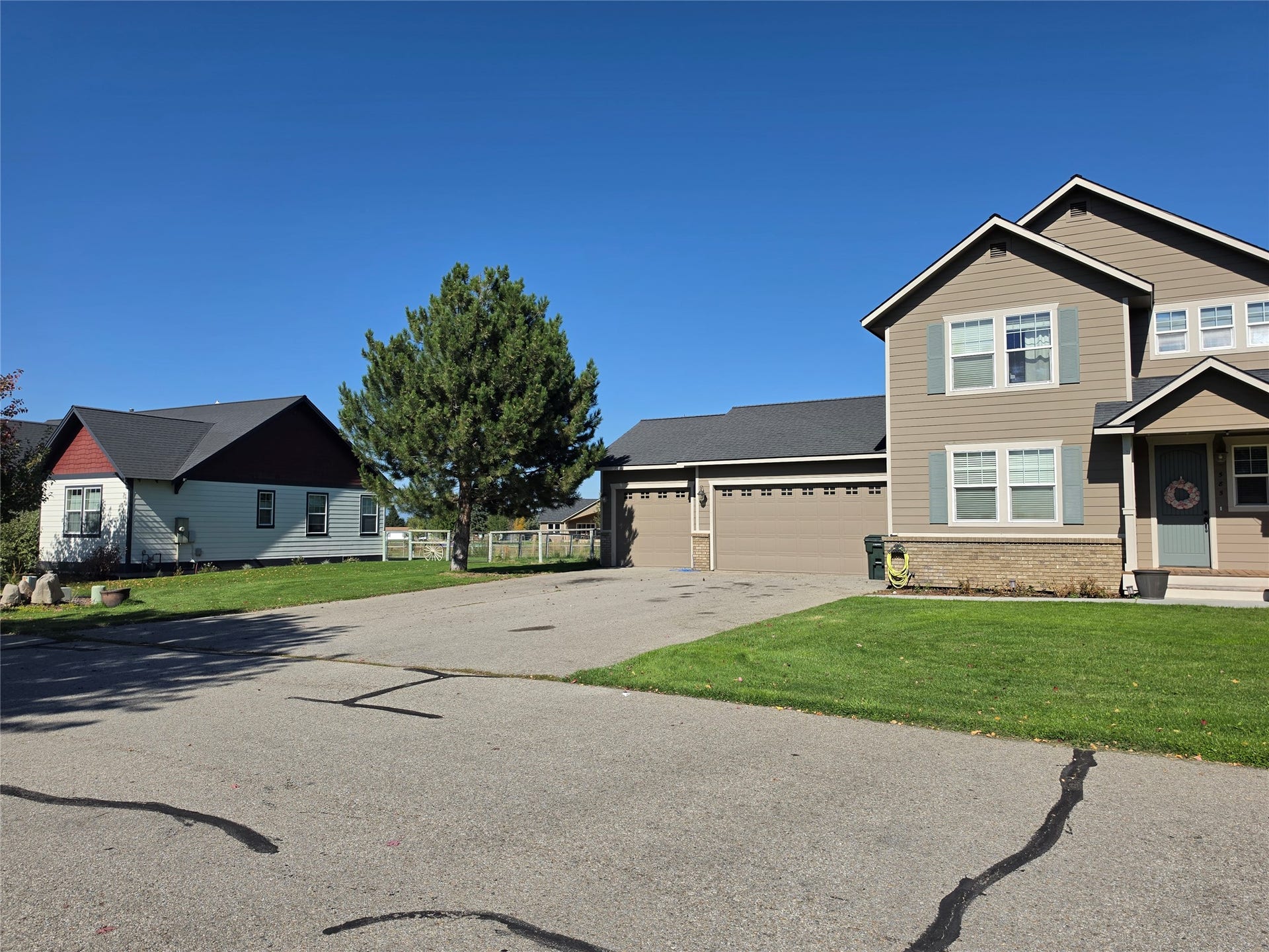 585 Wildflower Circle, Hamilton, MT 59840 Exterior featuring a two-story design, an attached garage, a stone-accented foundation, and a covered entry