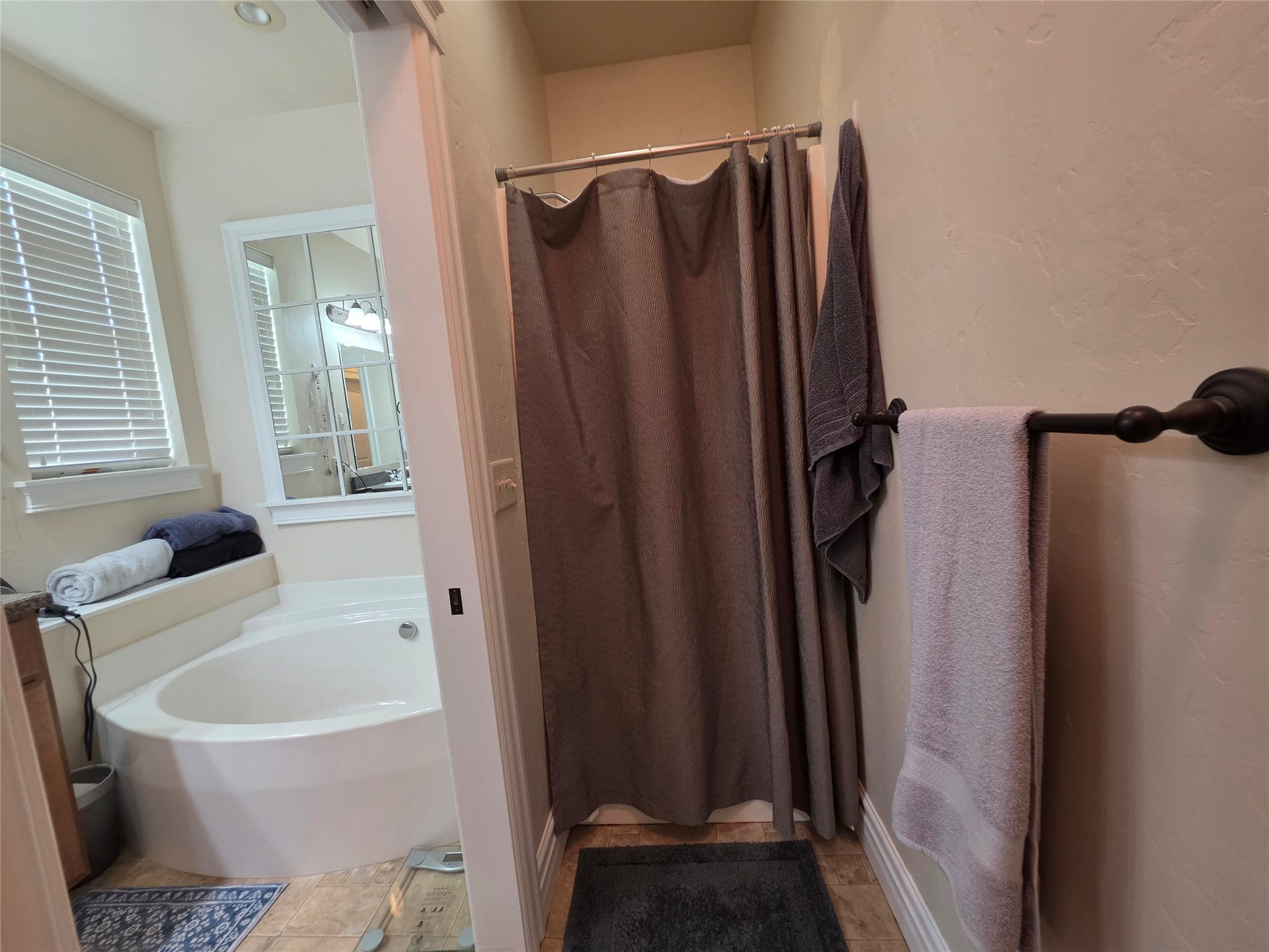 585 Wildflower Circle, Hamilton, MT 59840 Soaking tub with tiled surround, adjacent to a shower enclosure