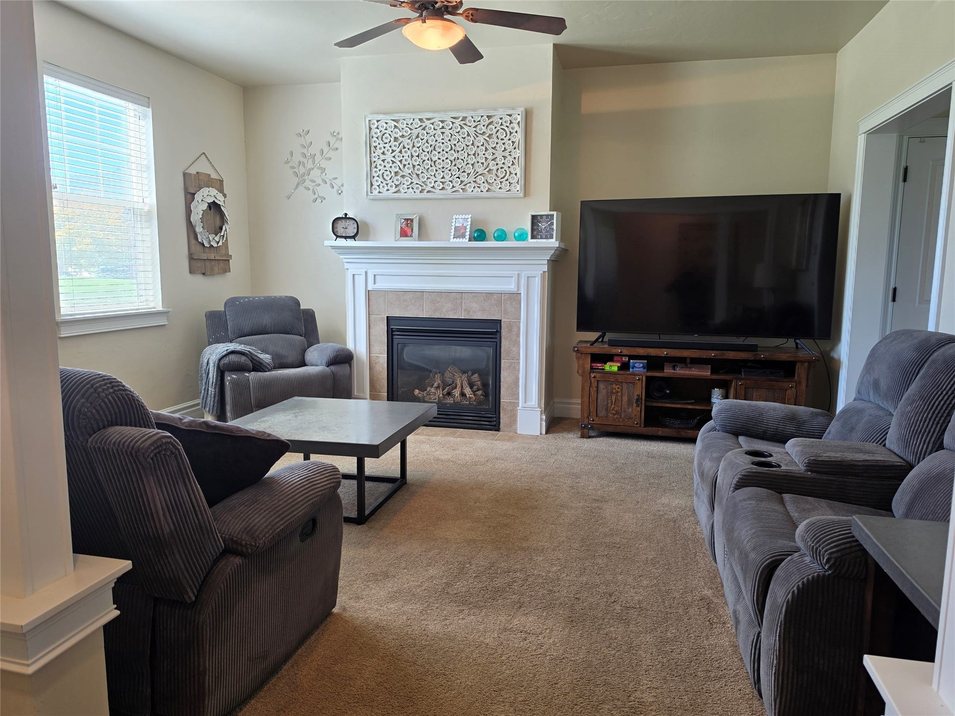 585 Wildflower Circle, Hamilton, MT 59840 Living area featuring a fireplace with a mantel, a ceiling fan with integrated lighting, and carpet flooring