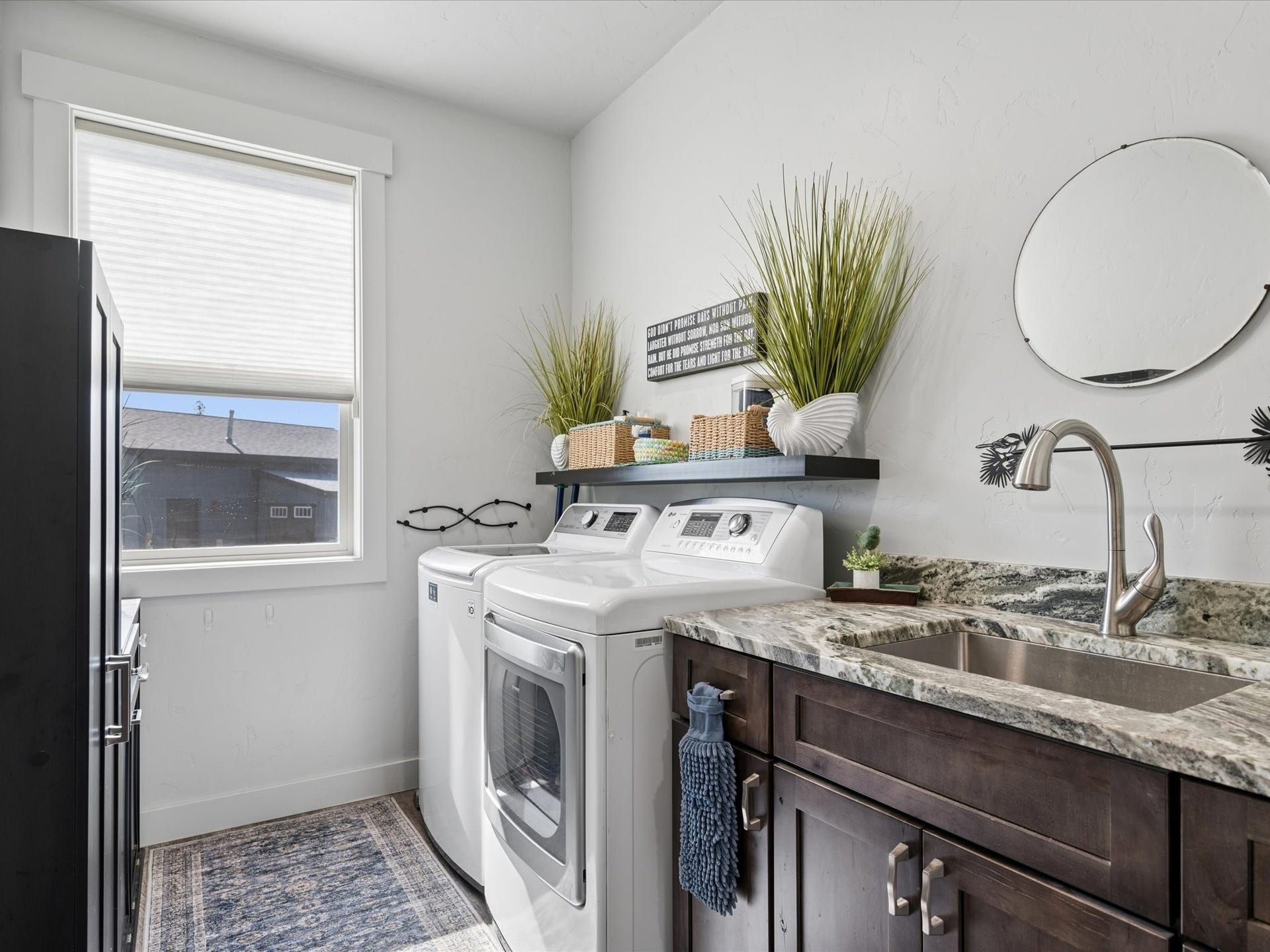 148 Fox Den Trail, Kalispell, MT 59901 Laundry area with a window, dark wood-finish cabinetry, a single basin sink, a high-arc faucet, and a granite countertop