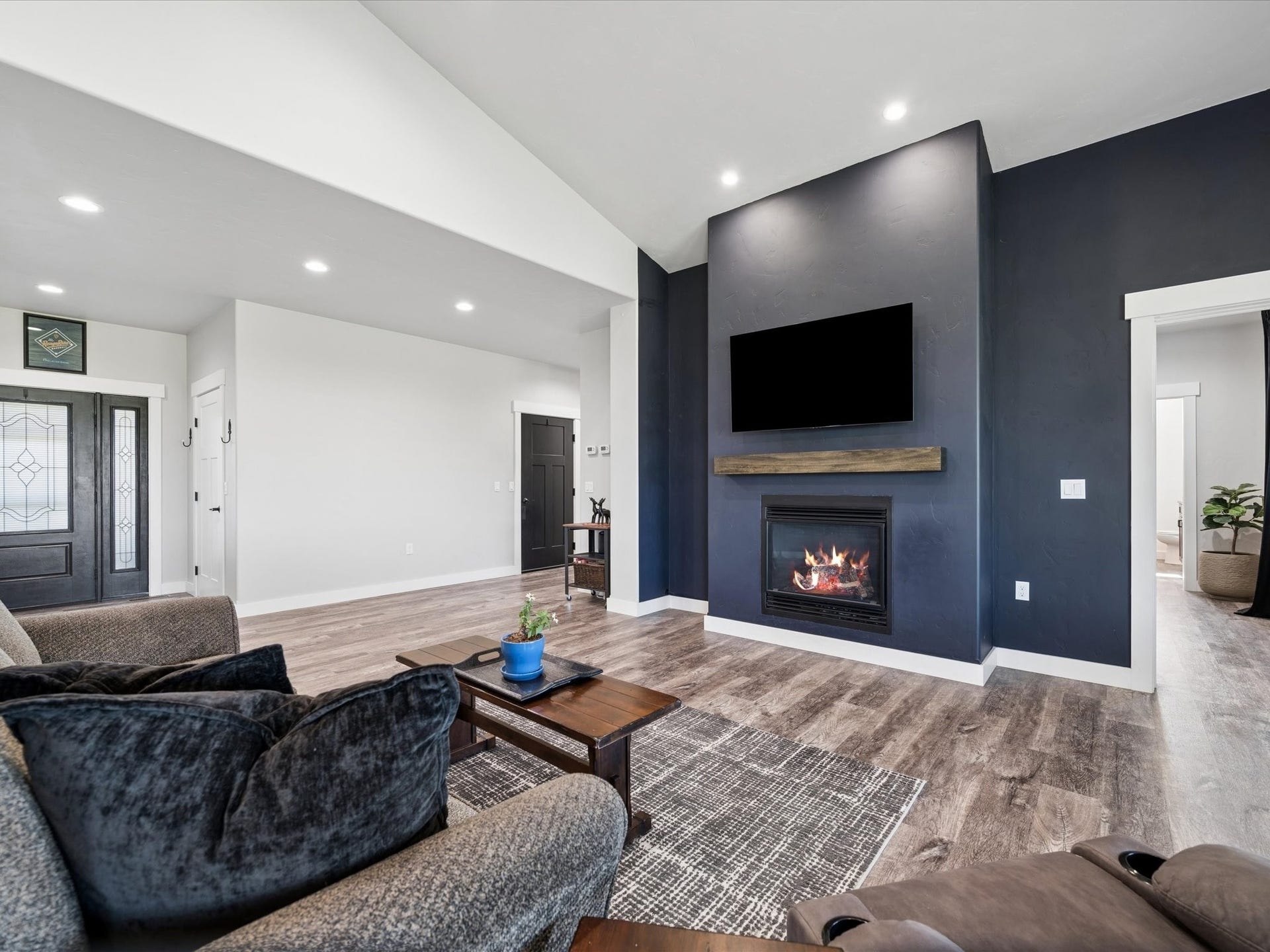 148 Fox Den Trail, Kalispell, MT 59901 Vaulted ceiling, recessed lighting, wood-finish flooring, built-in fireplace with wood mantel, and a dark accent wall