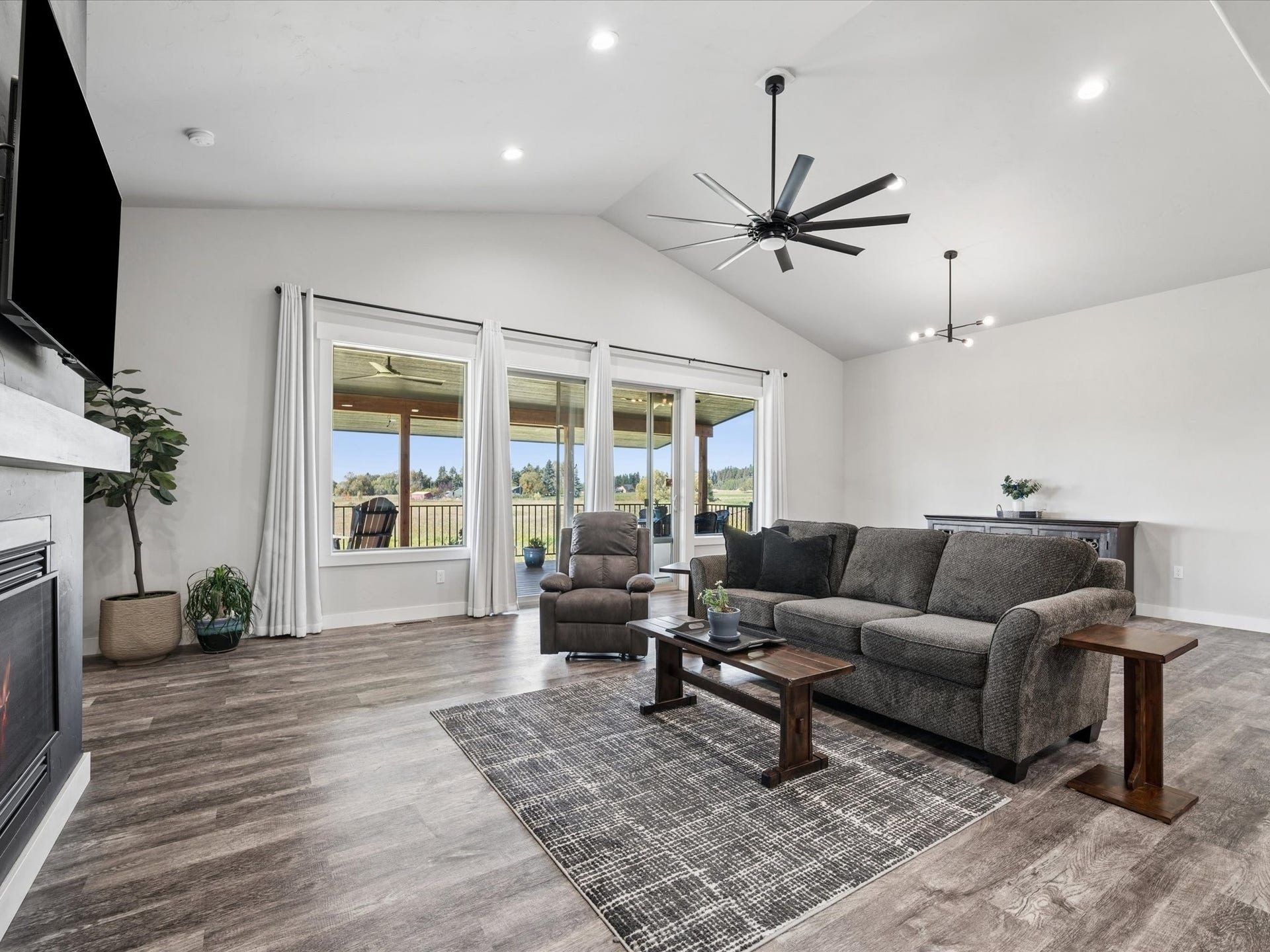 148 Fox Den Trail, Kalispell, MT 59901 Vaulted ceiling with a contemporary ceiling fan, recessed lighting, wood-finish flooring, and a fireplace with a mantel