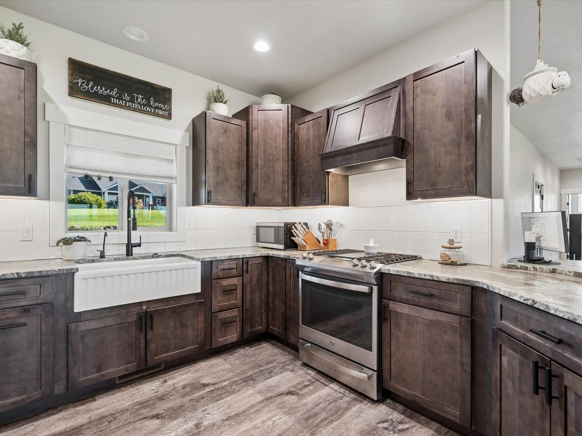 148 Fox Den Trail, Kalispell, MT 59901 Kitchen featuring wood-finish flooring, dark wood cabinetry, a white apron-front sink, white subway tile backsplash