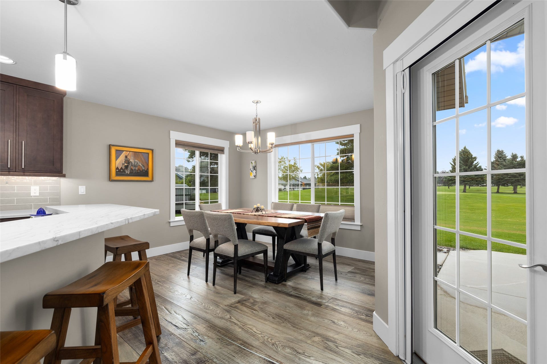 177 Palmer Drive, Kalispell, MT 59901 Open-concept dining and kitchen space featuring wood-finish flooring, a pendant light fixture, and large windows