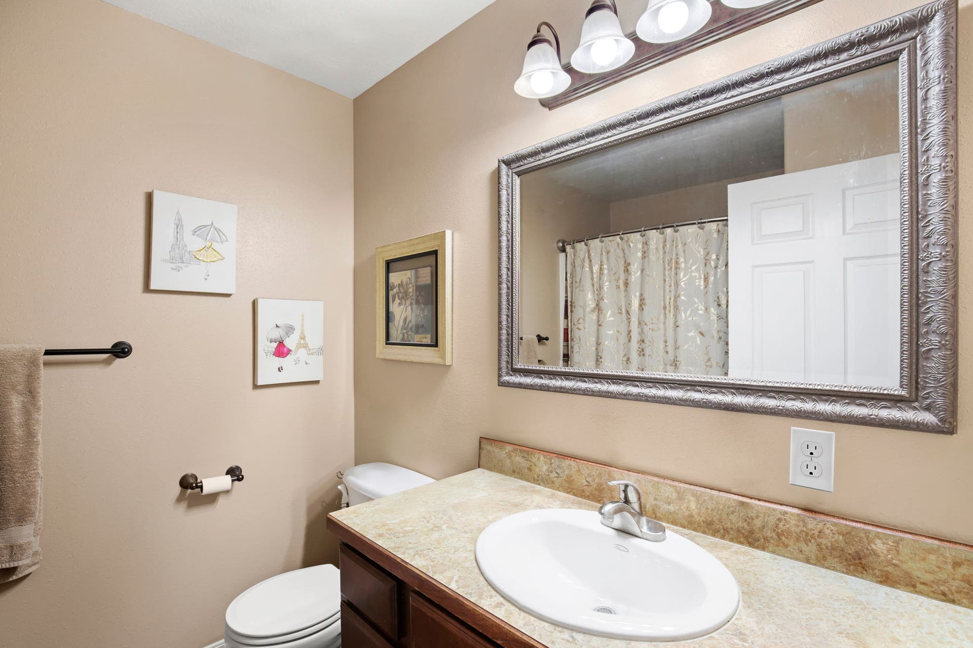 2541 Castle Pines Way, Great Falls, MT 59405 Bathroom featuring a built-in vanity with a laminate countertop, an oval undermount sink, and a framed mirror with an overhead light fixture