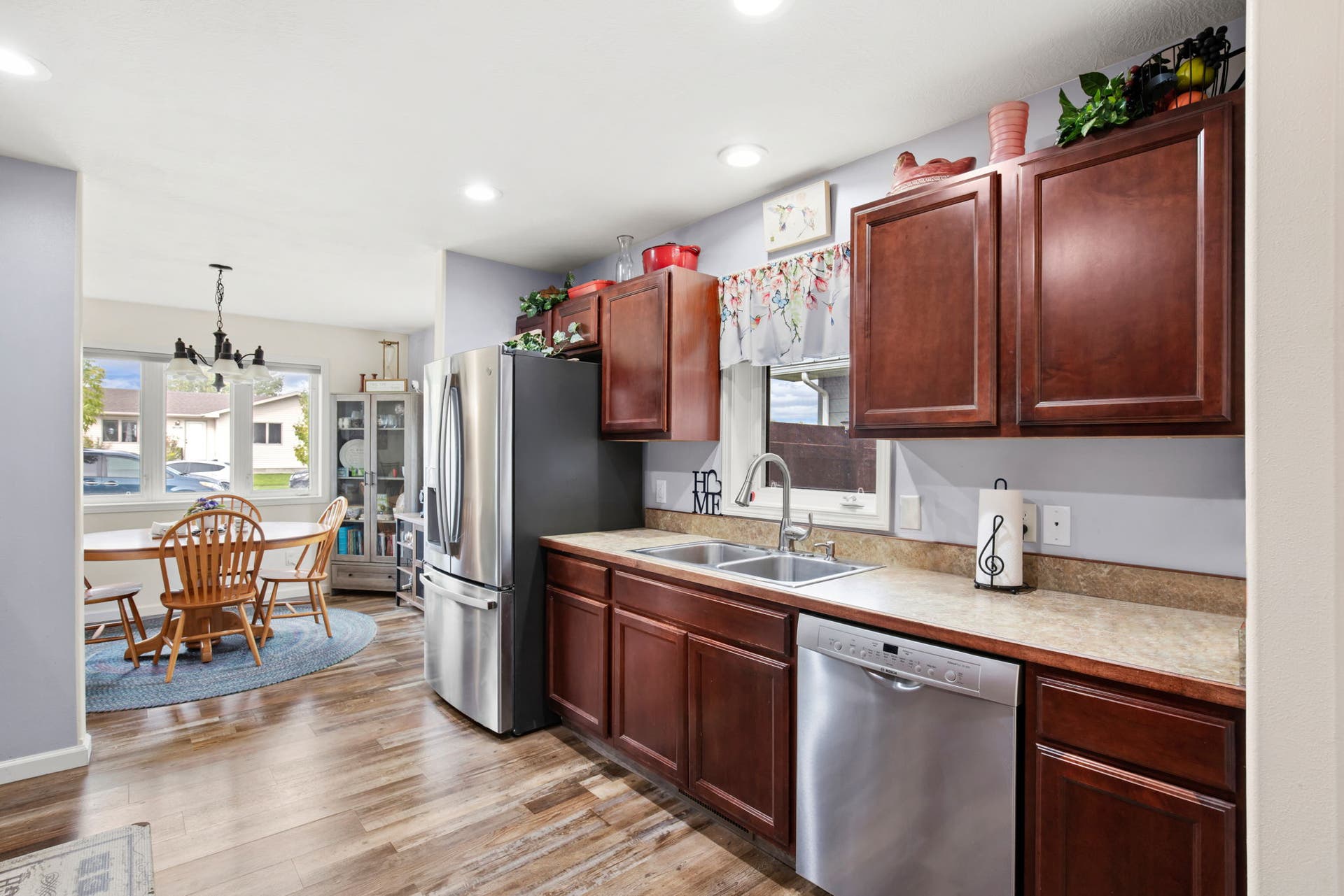 2541 Castle Pines Way, Great Falls, MT 59405 Kitchen featuring wood-finish flooring, dark wood cabinetry, stainless steel appliances, and a double basin sink
