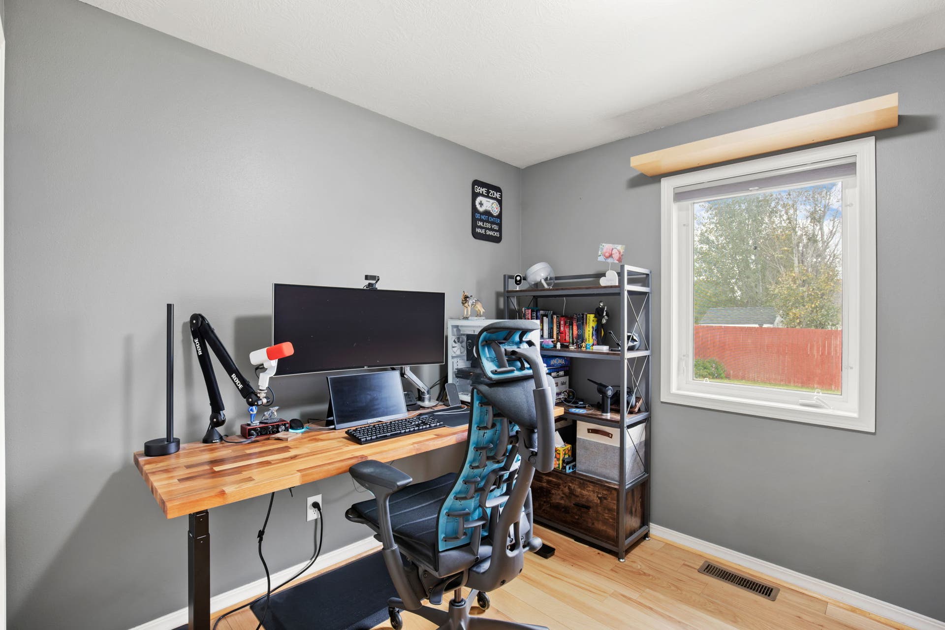 2541 Castle Pines Way, Great Falls, MT 59405 Natural wood-finish flooring, light grey painted walls, and a white window frame with a neutral-toned roller blind
