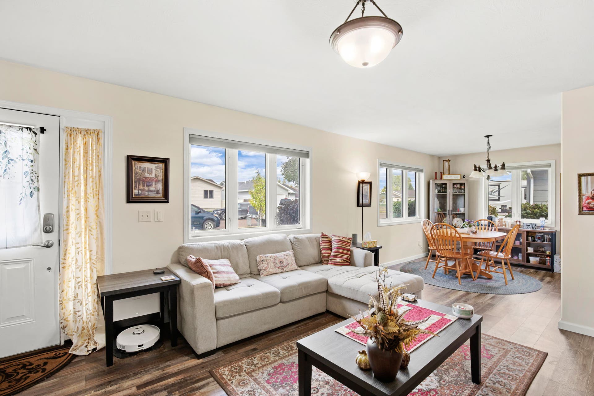 2541 Castle Pines Way, Great Falls, MT 59405 Open-concept living space featuring wood-finish flooring, multiple windows, and a dining area with a chandelier