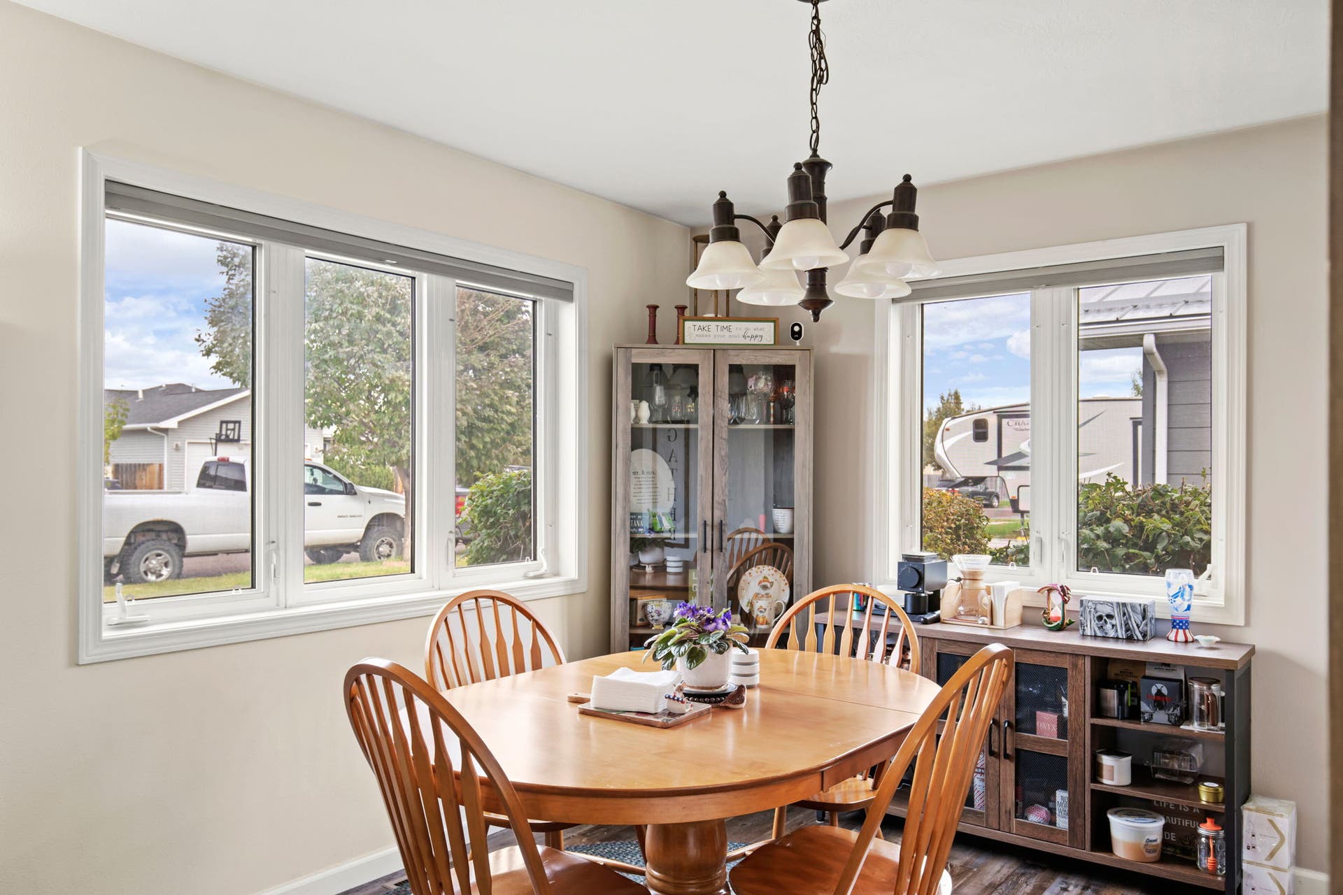 2541 Castle Pines Way, Great Falls, MT 59405 Spacious dining area featuring multiple large windows, wood-finish flooring, and a decorative chandelier