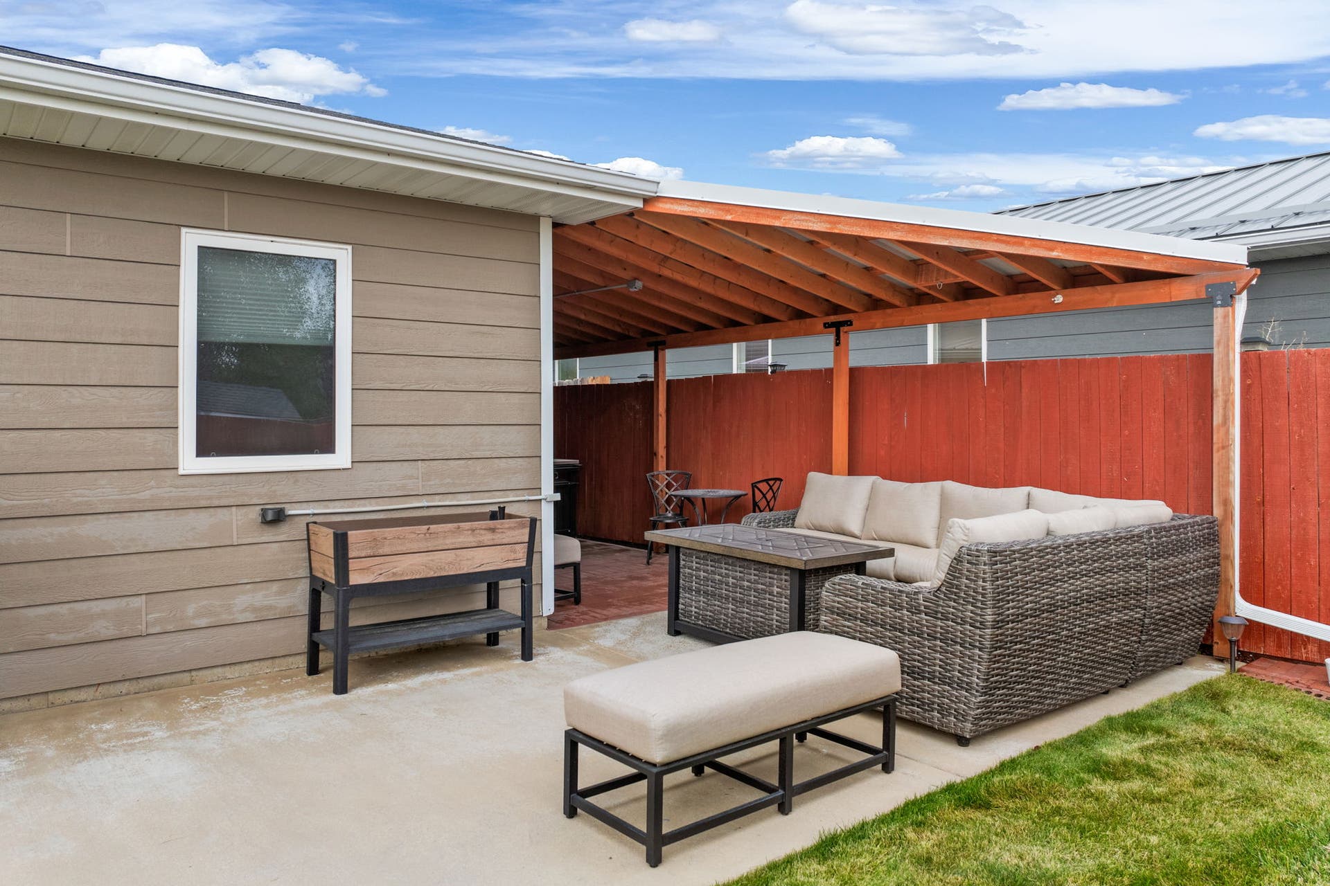 2541 Castle Pines Way, Great Falls, MT 59405 Covered patio with exposed wood beams, concrete surface, and adjacent grass area