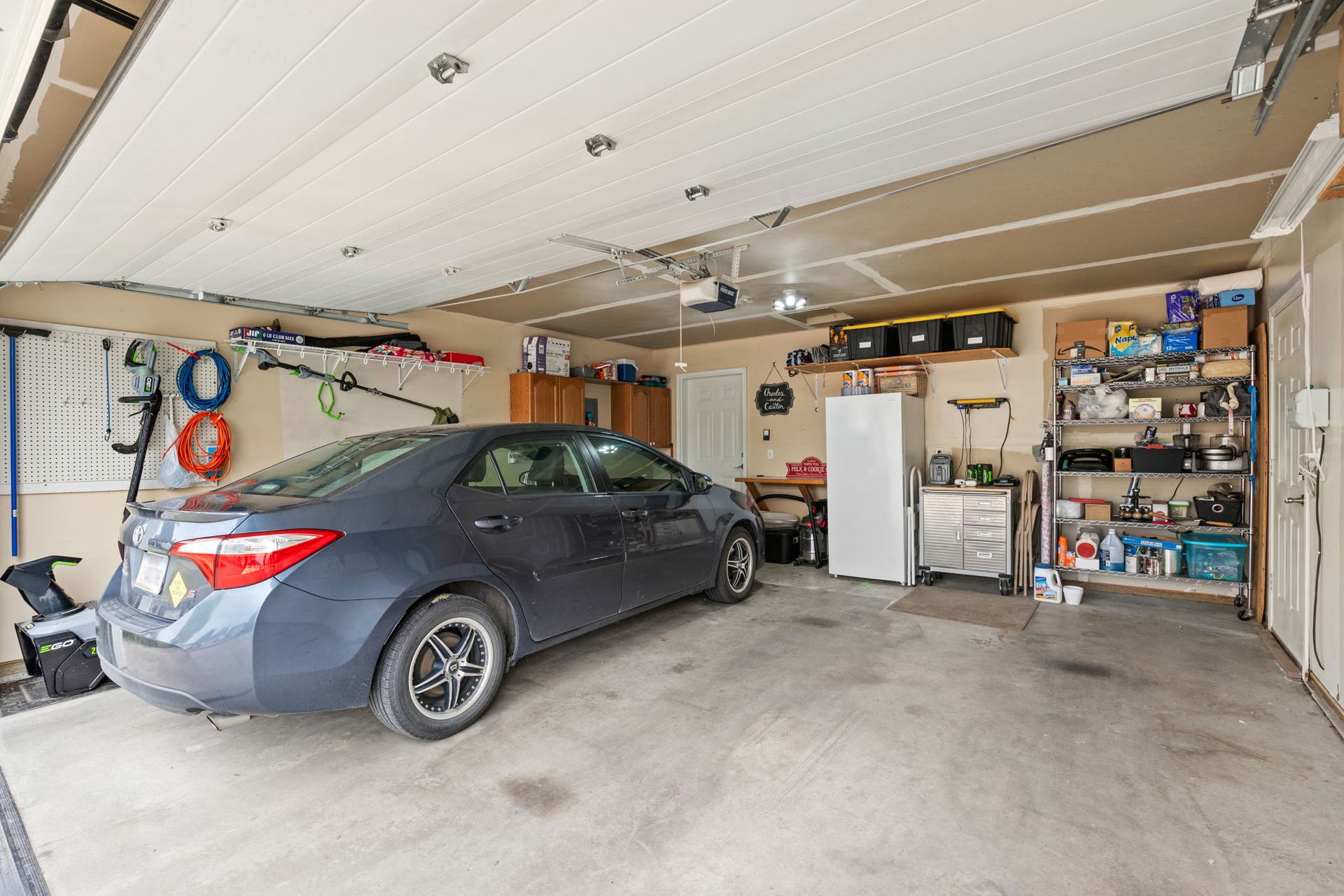 2541 Castle Pines Way, Great Falls, MT 59405 Attached garage with concrete flooring, overhead lighting, and built-in shelving units