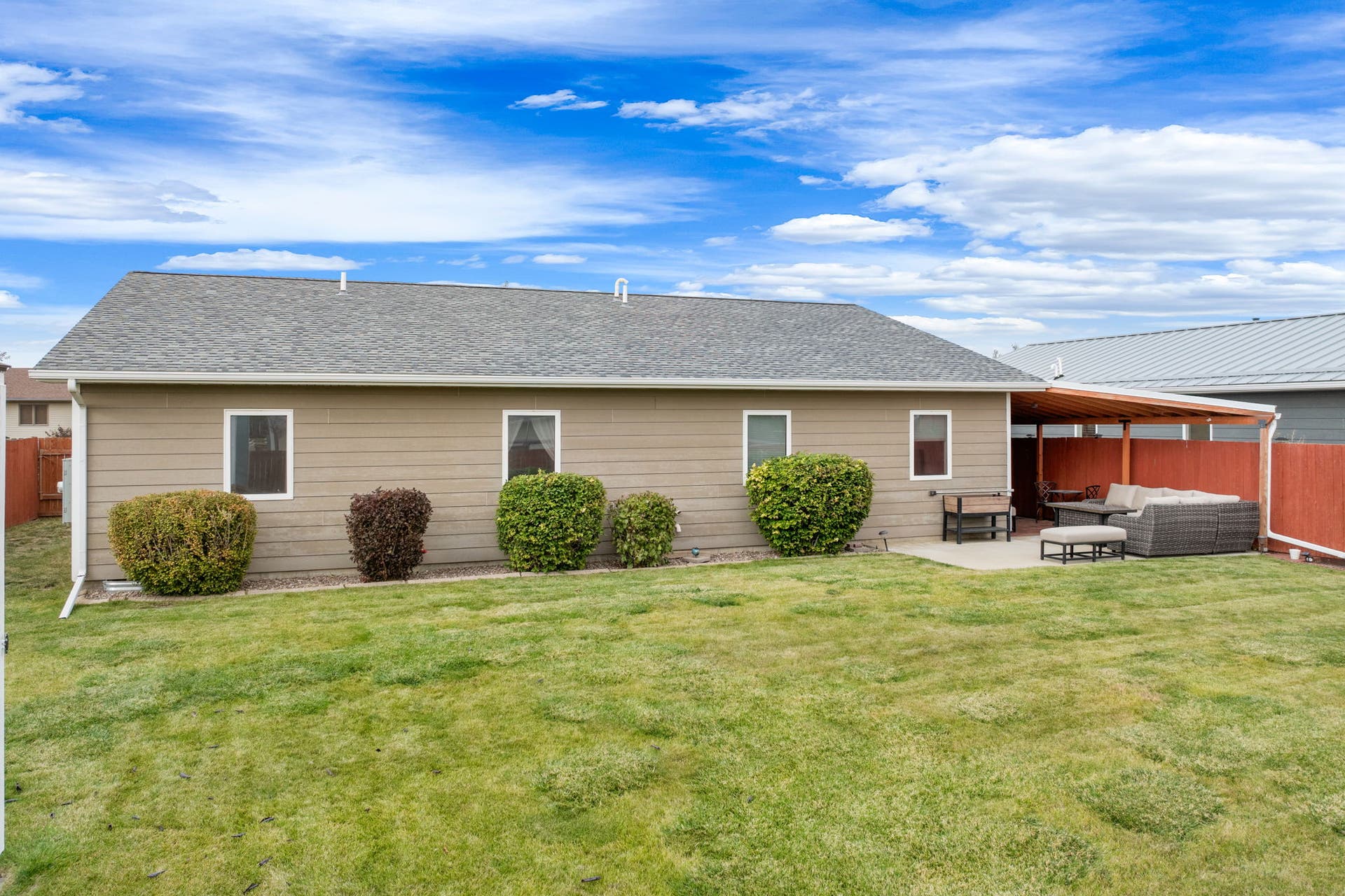 2541 Castle Pines Way, Great Falls, MT 59405 Expansive backyard featuring a manicured lawn, concrete patio, and an attached wood pergola