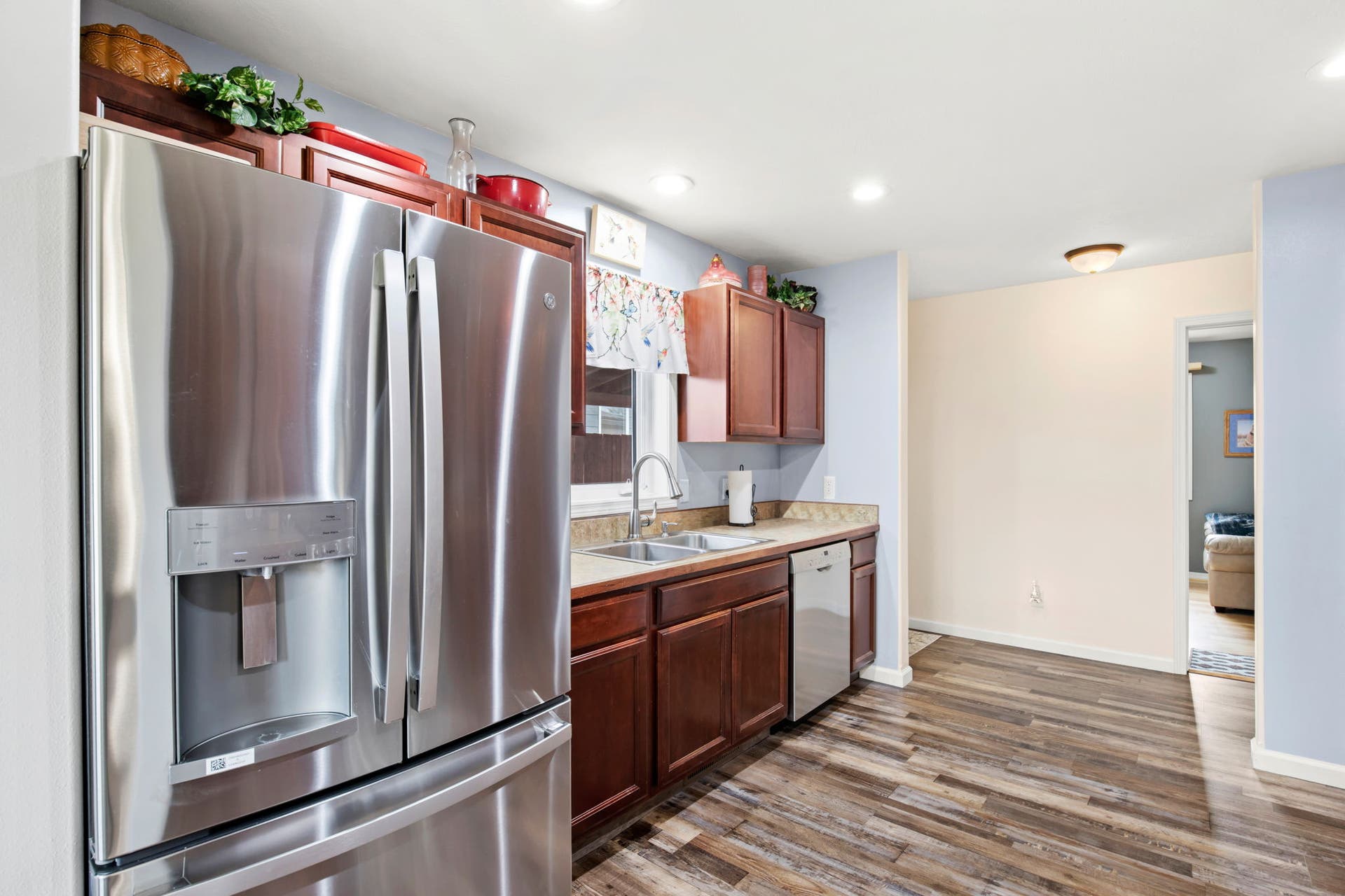 2541 Castle Pines Way, Great Falls, MT 59405 Stainless steel refrigerator with a built-in dispenser, wood-finish flooring, recessed lighting, and a stainless steel dishwasher