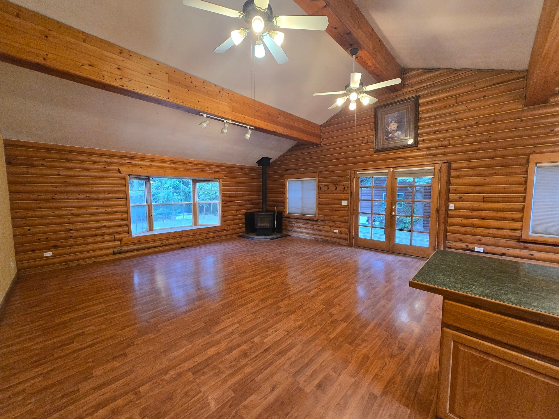 great room with vaulted ceilings, bay window, wood stove