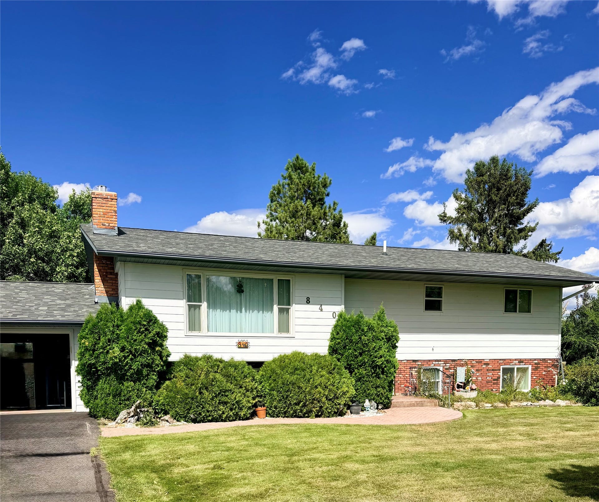 Split-level exterior with white siding and brick accents