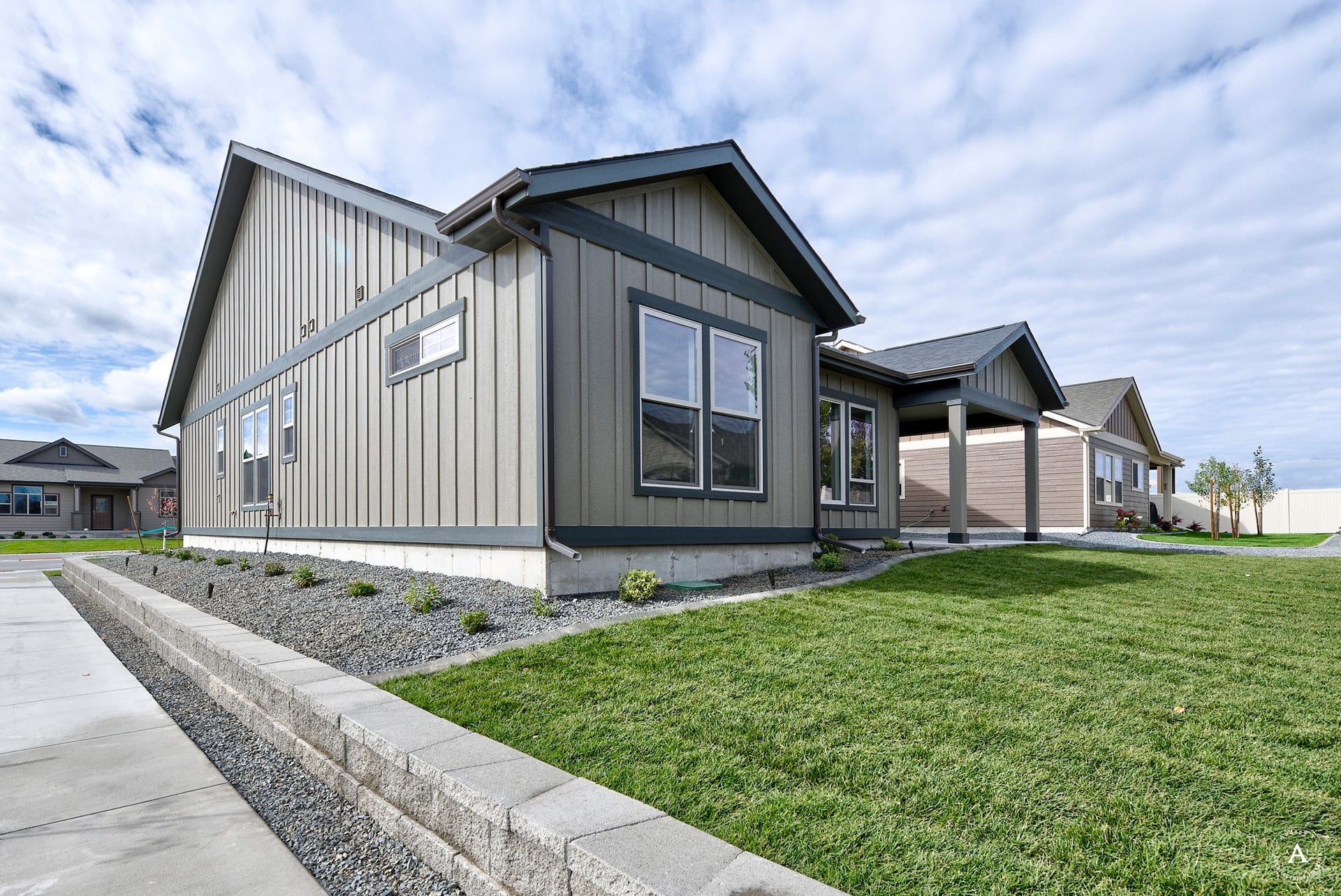2754 Lone Chief Loop, Helena, MT 59601 Contemporary exterior featuring board and batten siding, multiple windows, a covered entry, and a manicured lawn