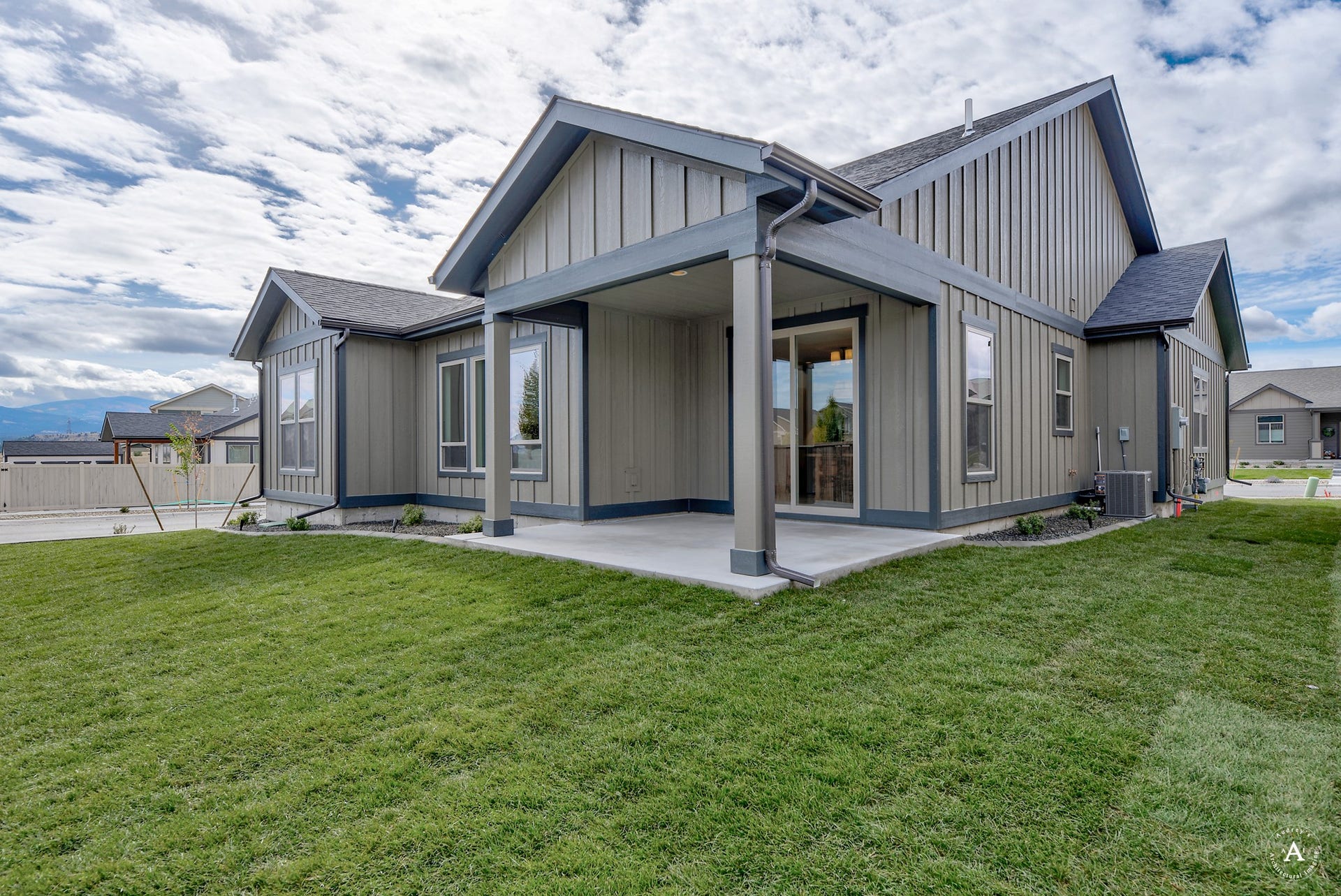 2754 Lone Chief Loop, Helena, MT 59601 Exterior featuring vertical board and batten siding, covered patio with concrete flooring, dark trim accents, and a sliding glass door