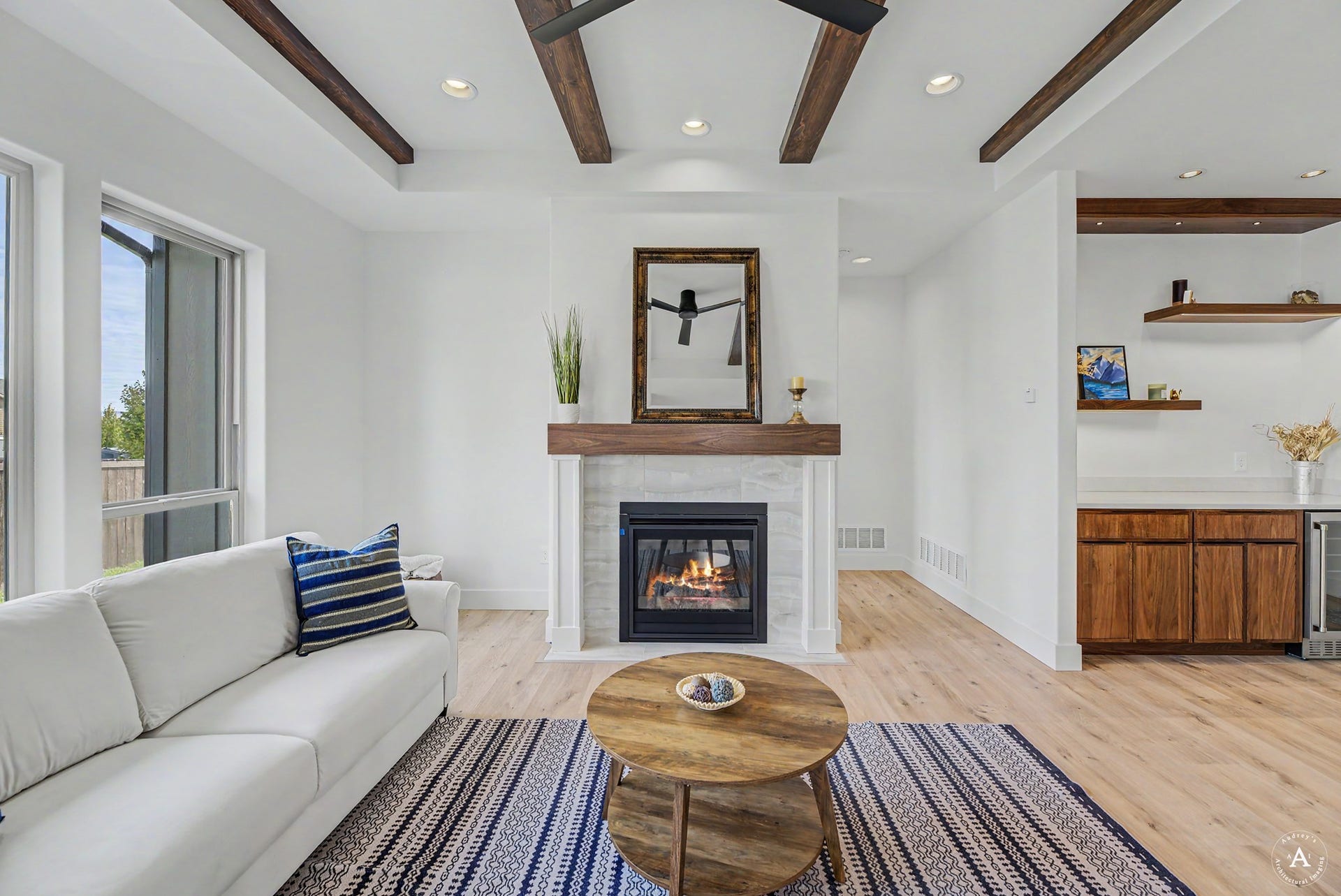 2754 Lone Chief Loop, Helena, MT 59601 Living area featuring a fireplace with a wood mantle, wood-finish flooring, and exposed ceiling beams