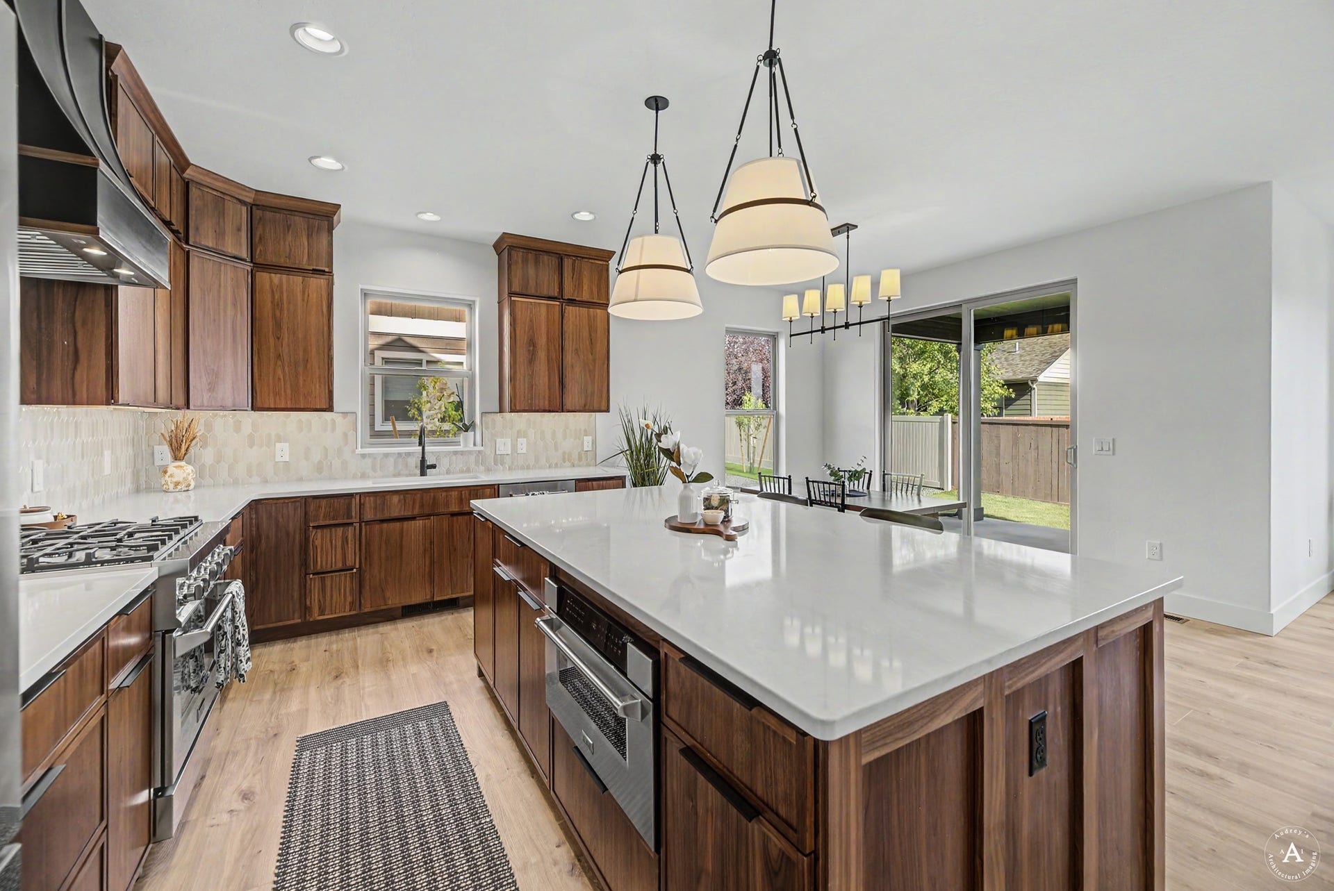 2754 Lone Chief Loop, Helena, MT 59601 Kitchen featuring wood-finish cabinetry, light-toned countertops, tile backsplash, built-in stainless steel appliances, and wood-finish flooring