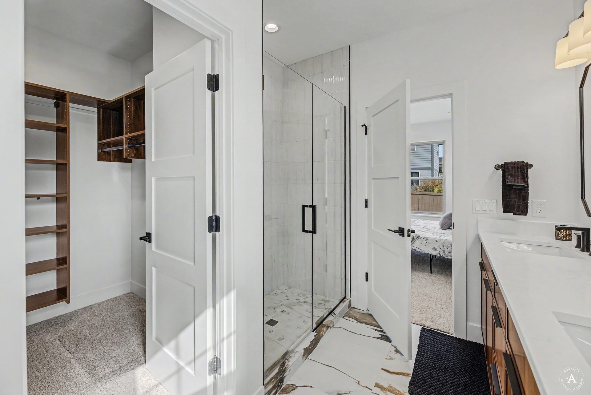 2754 Lone Chief Loop, Helena, MT 59601 Walk-in closet with custom wood shelving, glass-enclosed shower, dual vanity with undermount sinks, and white countertops