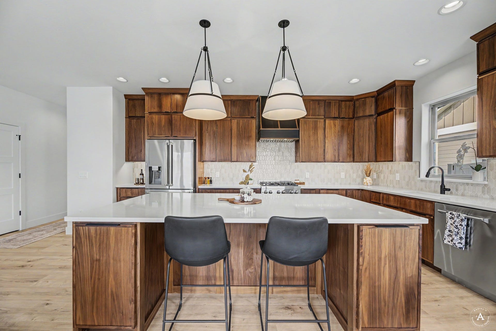 2754 Lone Chief Loop, Helena, MT 59601 Kitchen featuring wood-finish cabinetry, stainless steel appliances, a large center island with a white countertop, and a tiled backsplash