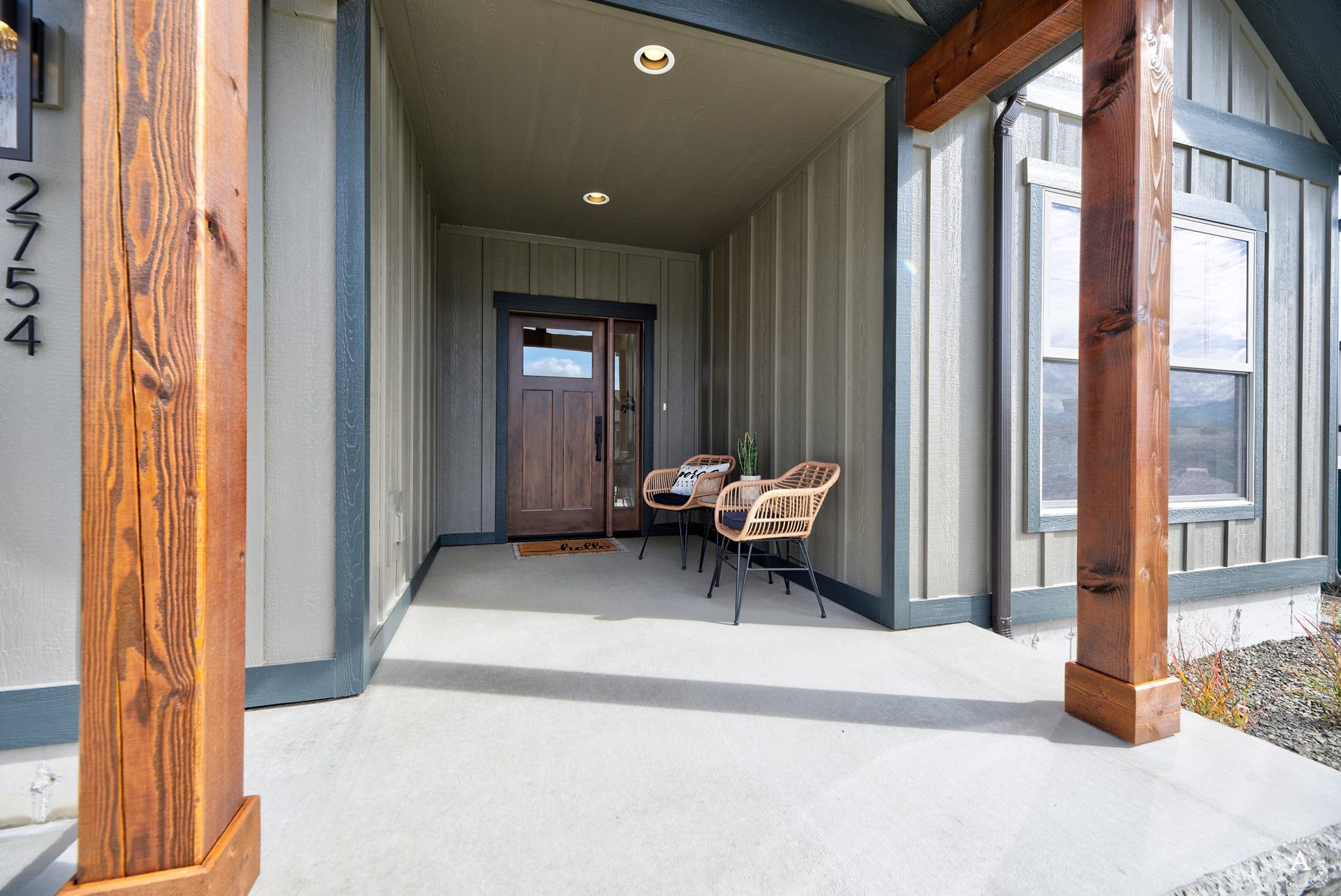 2754 Lone Chief Loop, Helena, MT 59601 Covered concrete front porch featuring recessed lighting, a wood-finish entry door with glass paneling, and board and batten siding