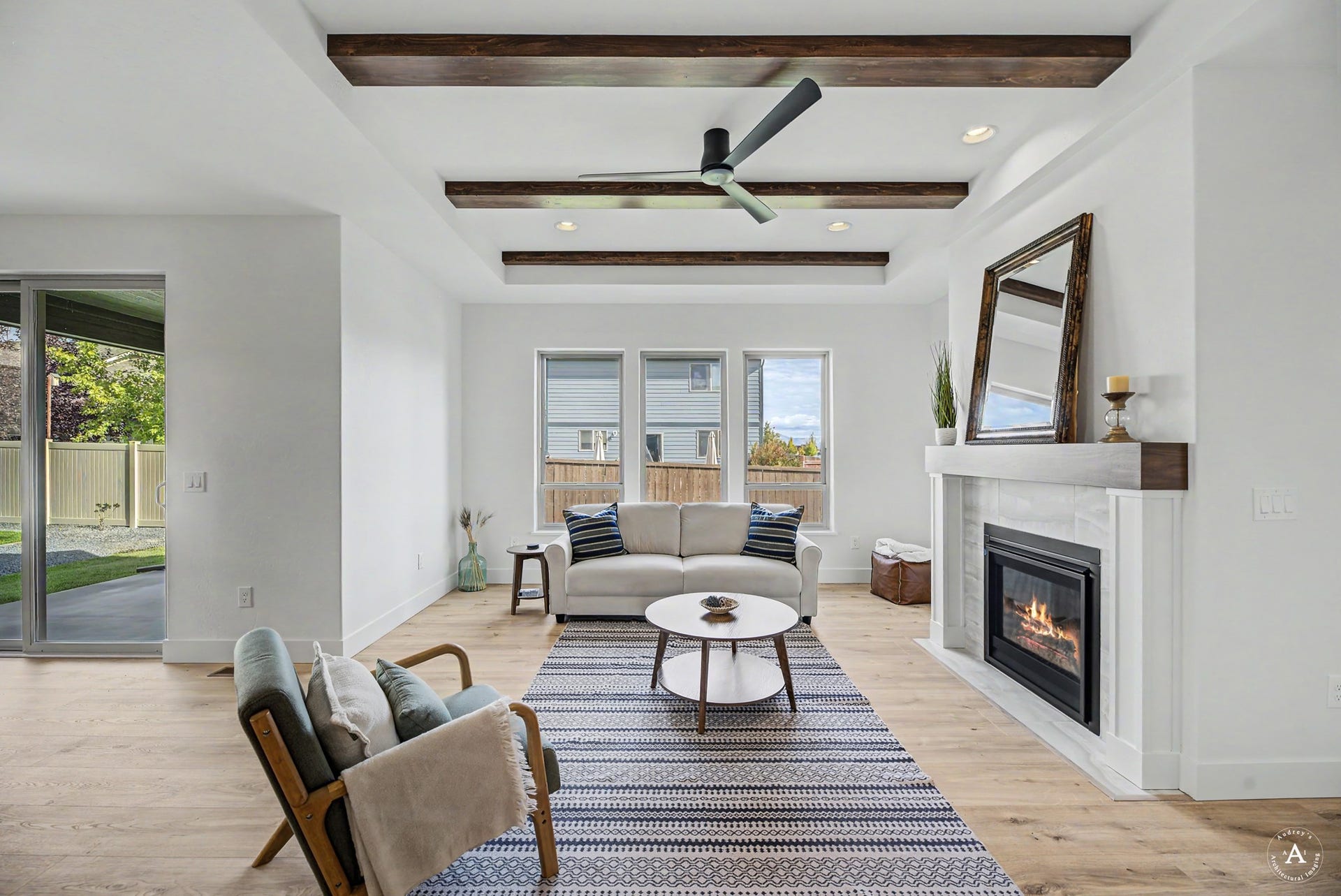 2754 Lone Chief Loop, Helena, MT 59601 Coffered ceiling with exposed wood beams, built-in fireplace with a tile surround, wood-finish flooring, recessed lighting, and a sliding glass door