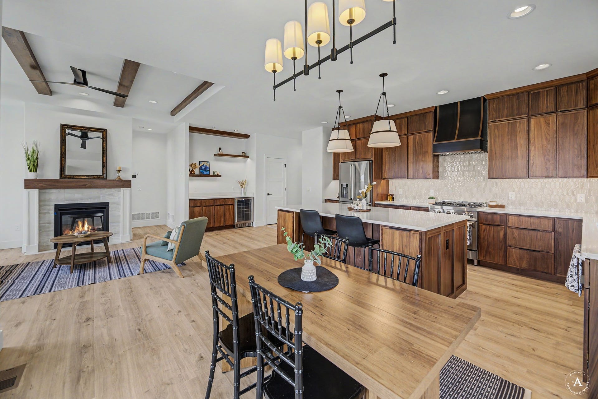 2754 Lone Chief Loop, Helena, MT 59601 Open-concept kitchen and living area featuring wood-finish flooring, a fireplace with a wood mantle, and a kitchen island with seating