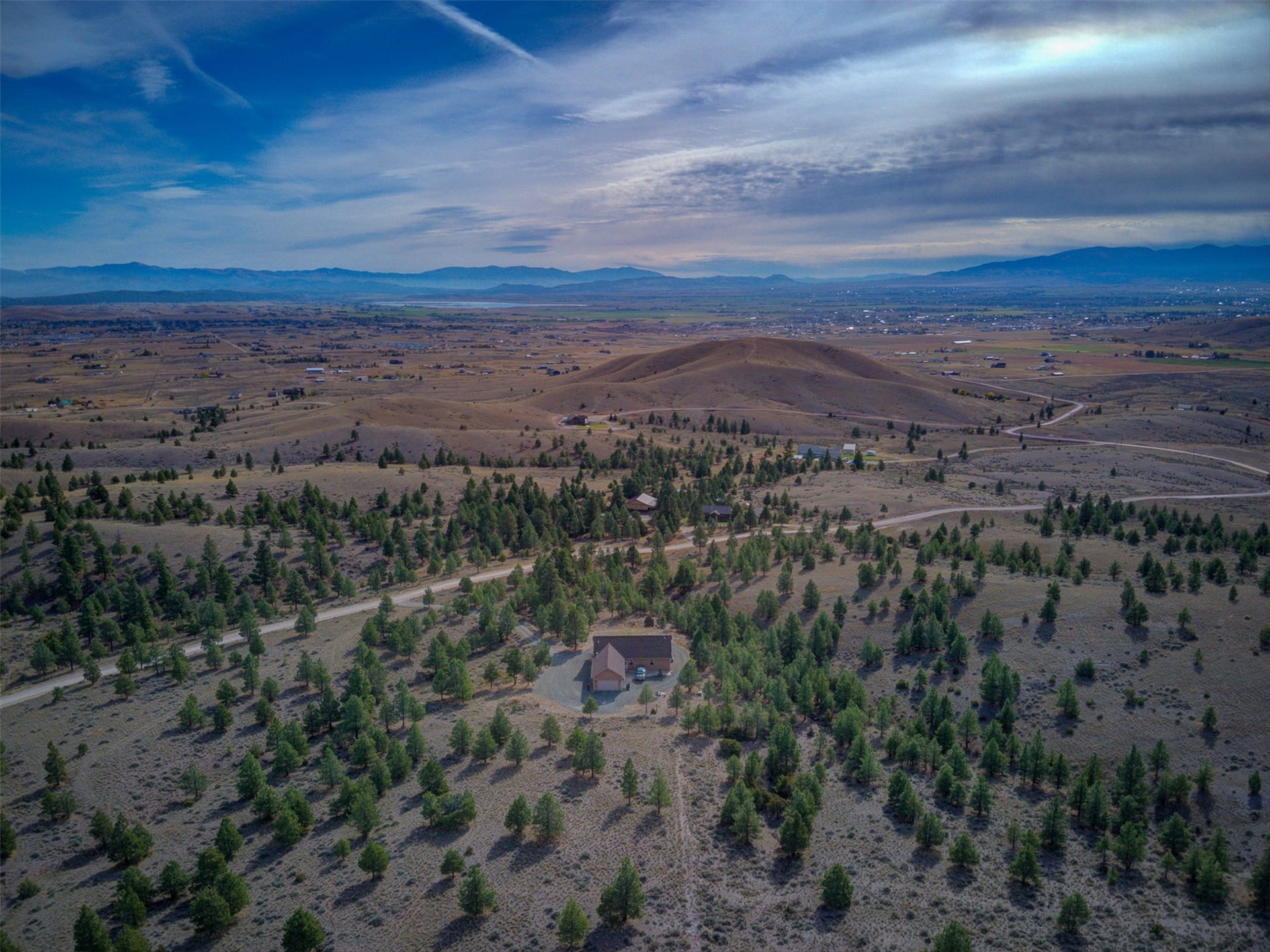 8224 Hillside Drive, Helena, MT 59602 Expansive desert-like landscape with scattered evergreen trees and distant mountain ranges