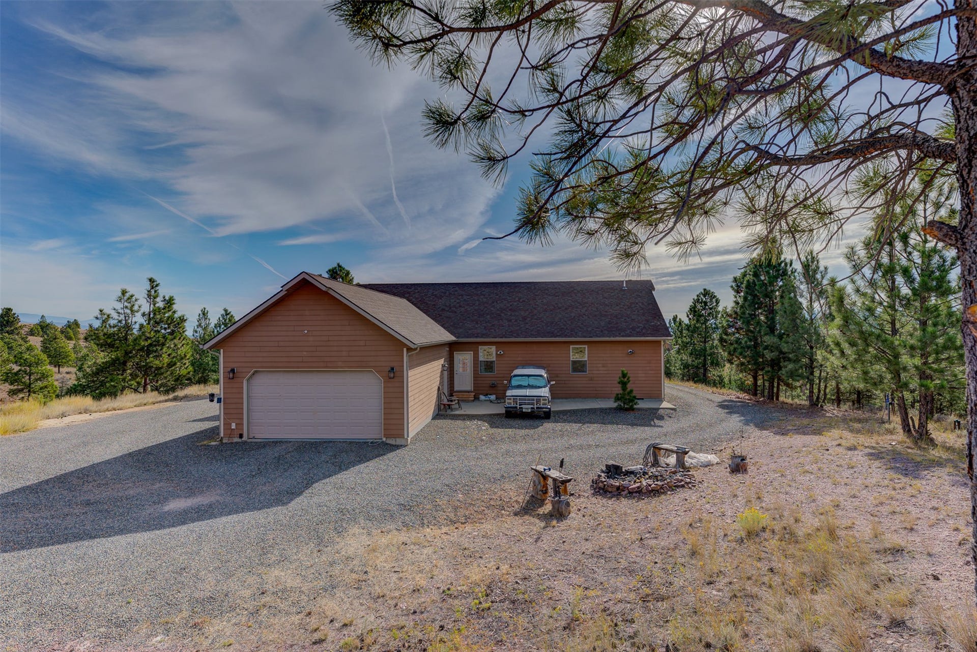 8224 Hillside Drive, Helena, MT 59602 Single-story residence featuring siding exterior, an attached garage, and a gravel driveway