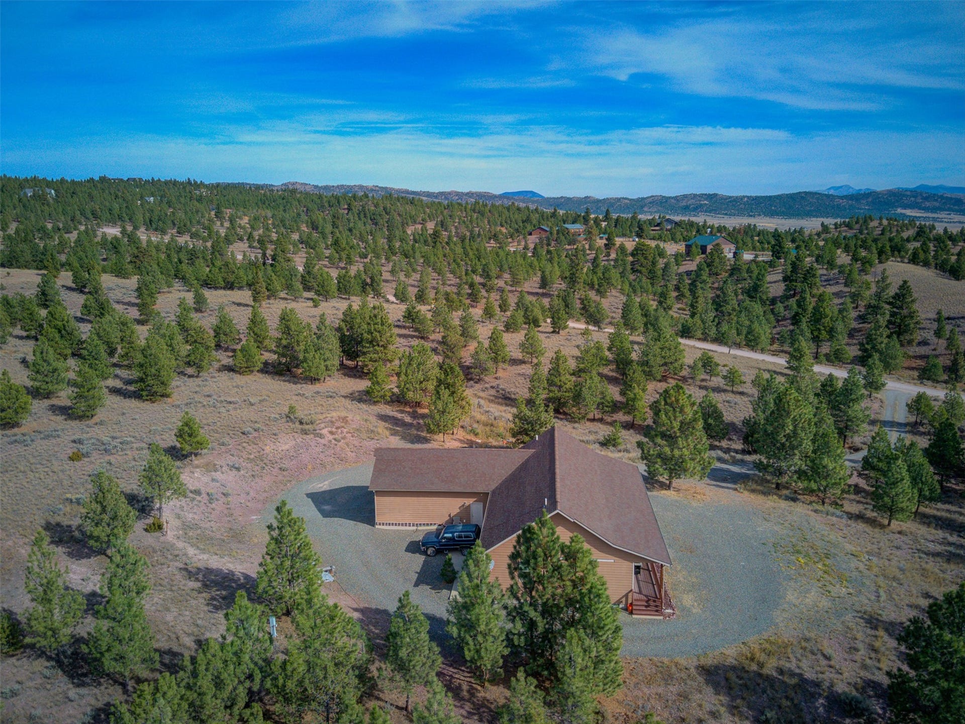8224 Hillside Drive, Helena, MT 59602 Single-story property with a brown exterior and a matching brown roof, surrounded by mature evergreen trees