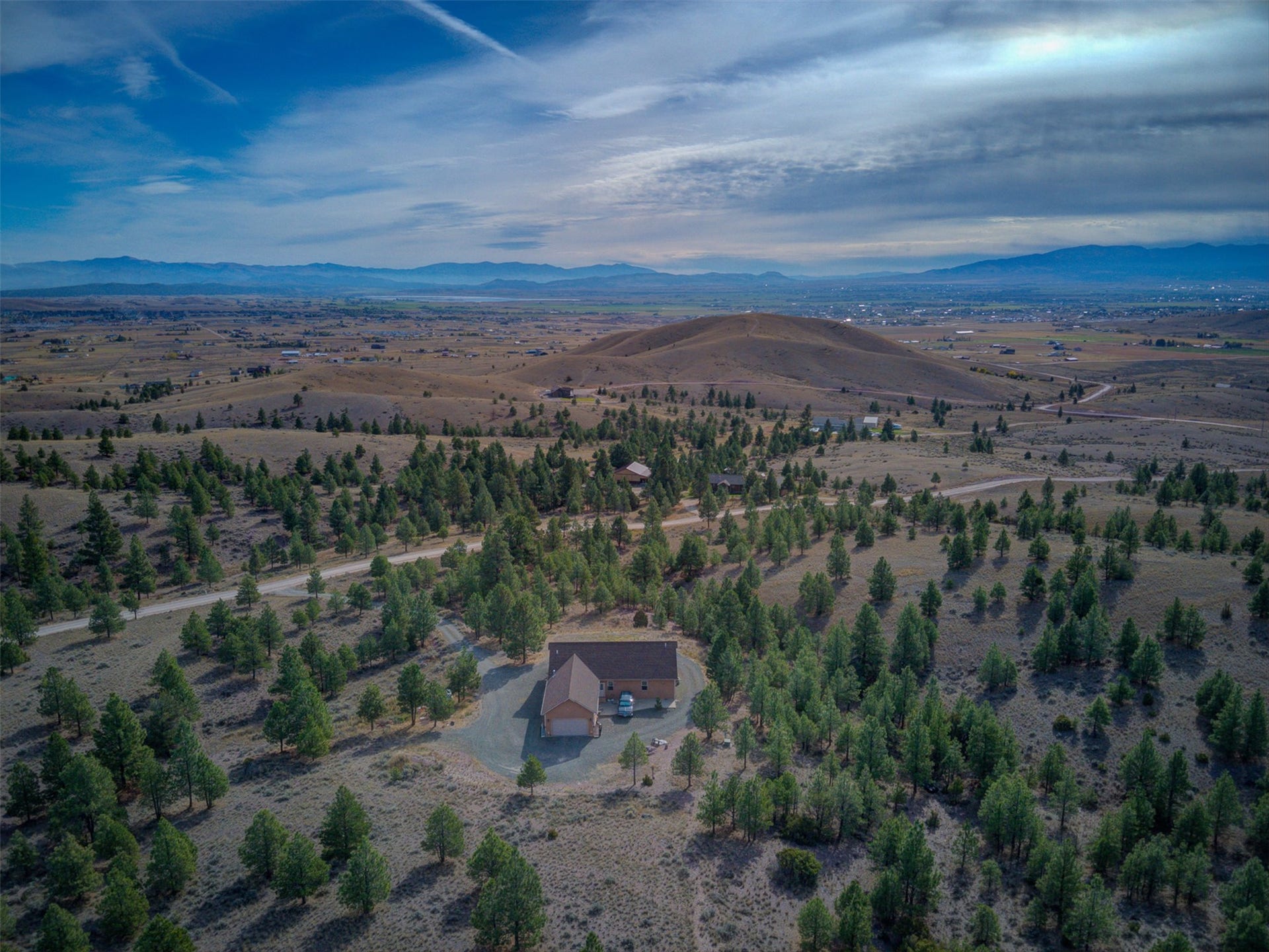 8224 Hillside Drive, Helena, MT 59602 Expansive acreage with a single-family residence, integrated two-car garage, and a gravel driveway