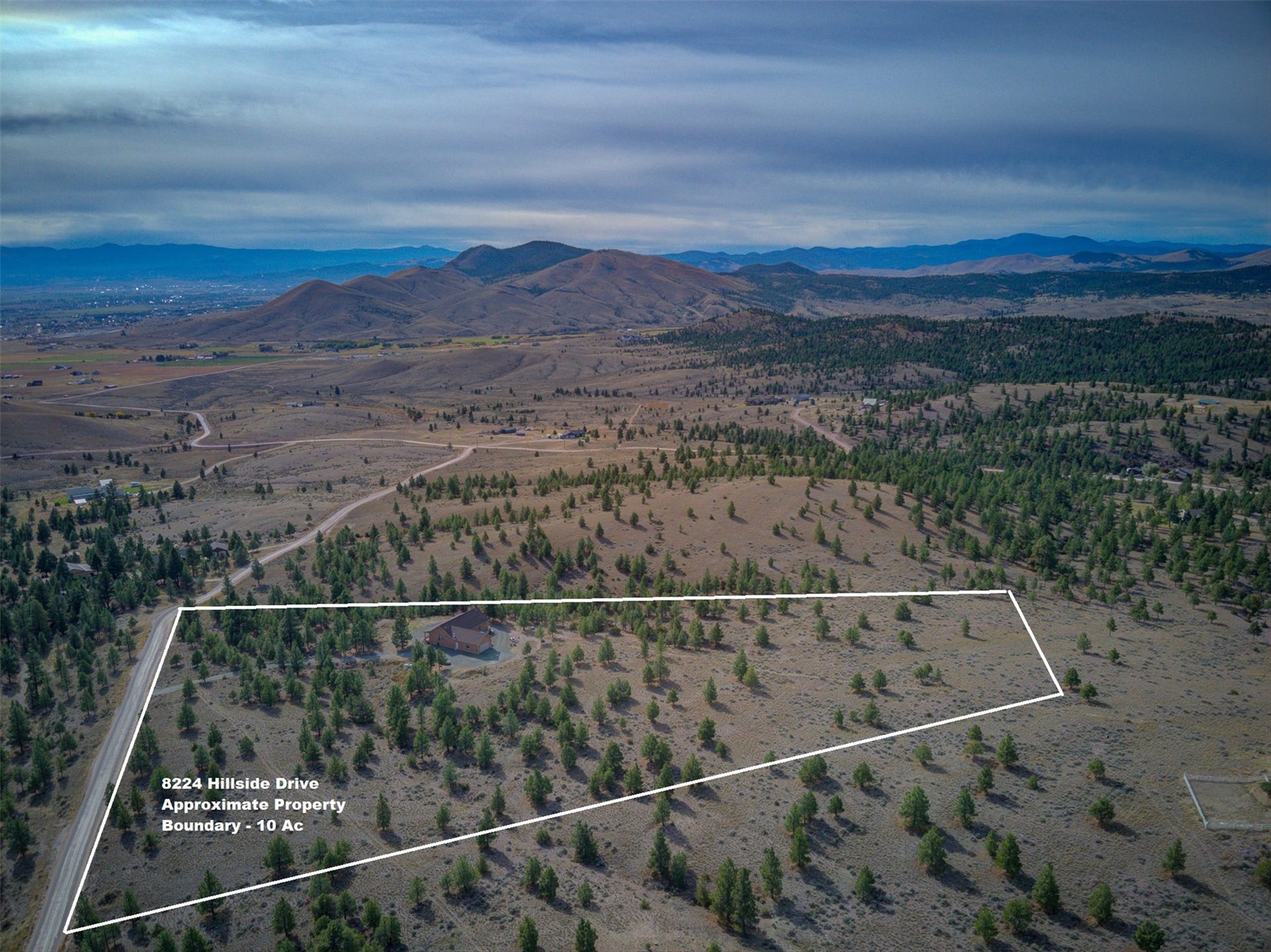 8224 Hillside Drive, Helena, MT 59602 Expansive 10-acre property featuring a single-family residence, mature trees, and a distant mountainous backdrop