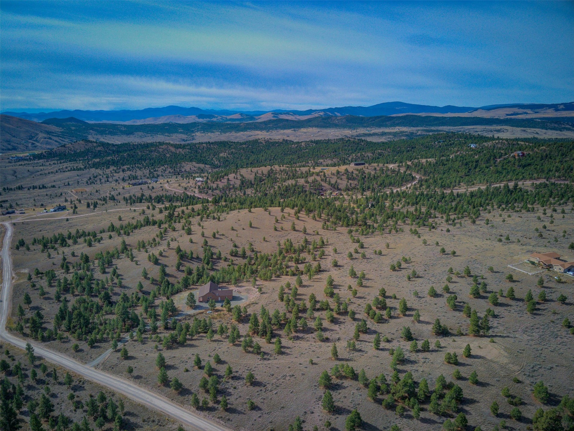 8224 Hillside Drive, Helena, MT 59602 Extensive property featuring natural terrain, scattered mature trees, and distant mountain ranges