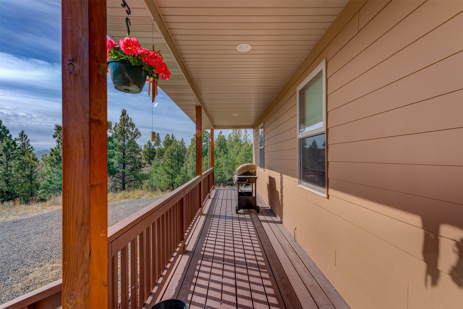 8224 Hillside Drive, Helena, MT 59602 Expansive covered porch with wood-finish decking and railing, recessed lighting, and horizontal siding
