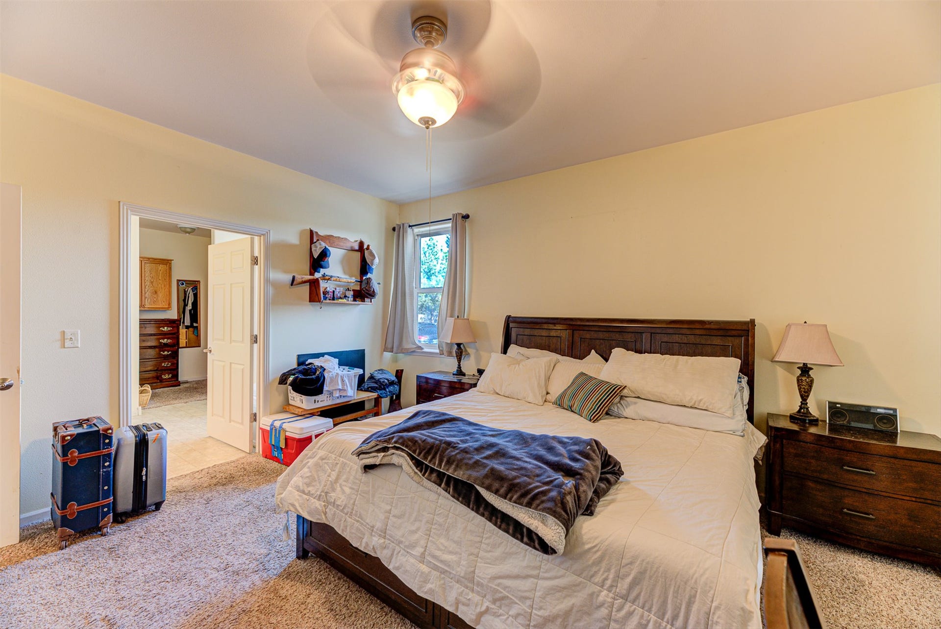 8224 Hillside Drive, Helena, MT 59602 Ceiling fan with integrated lighting, window with light-filtering curtains, and carpeted flooring