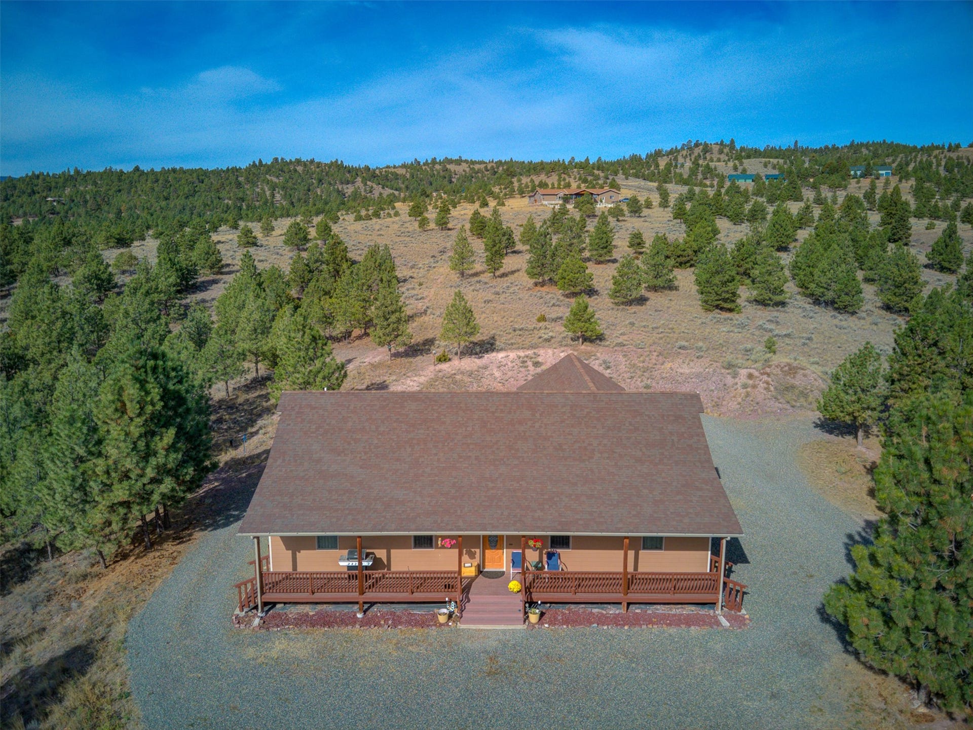 8224 Hillside Drive, Helena, MT 59602 Ranch-style residence featuring a covered front porch, gravel landscaping, and a brown shingle roof