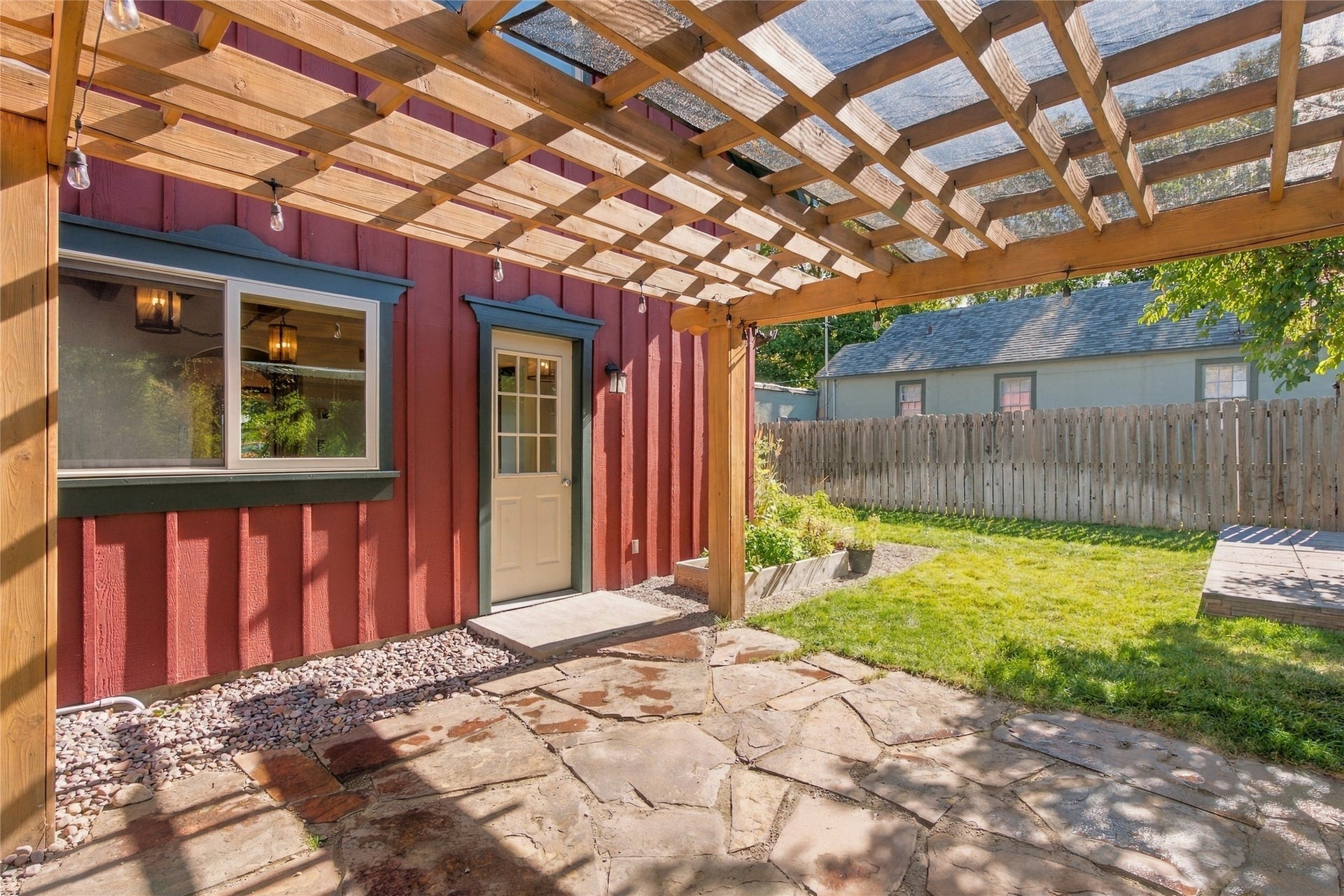 Wood pergola with translucent panels over a flagstone patio