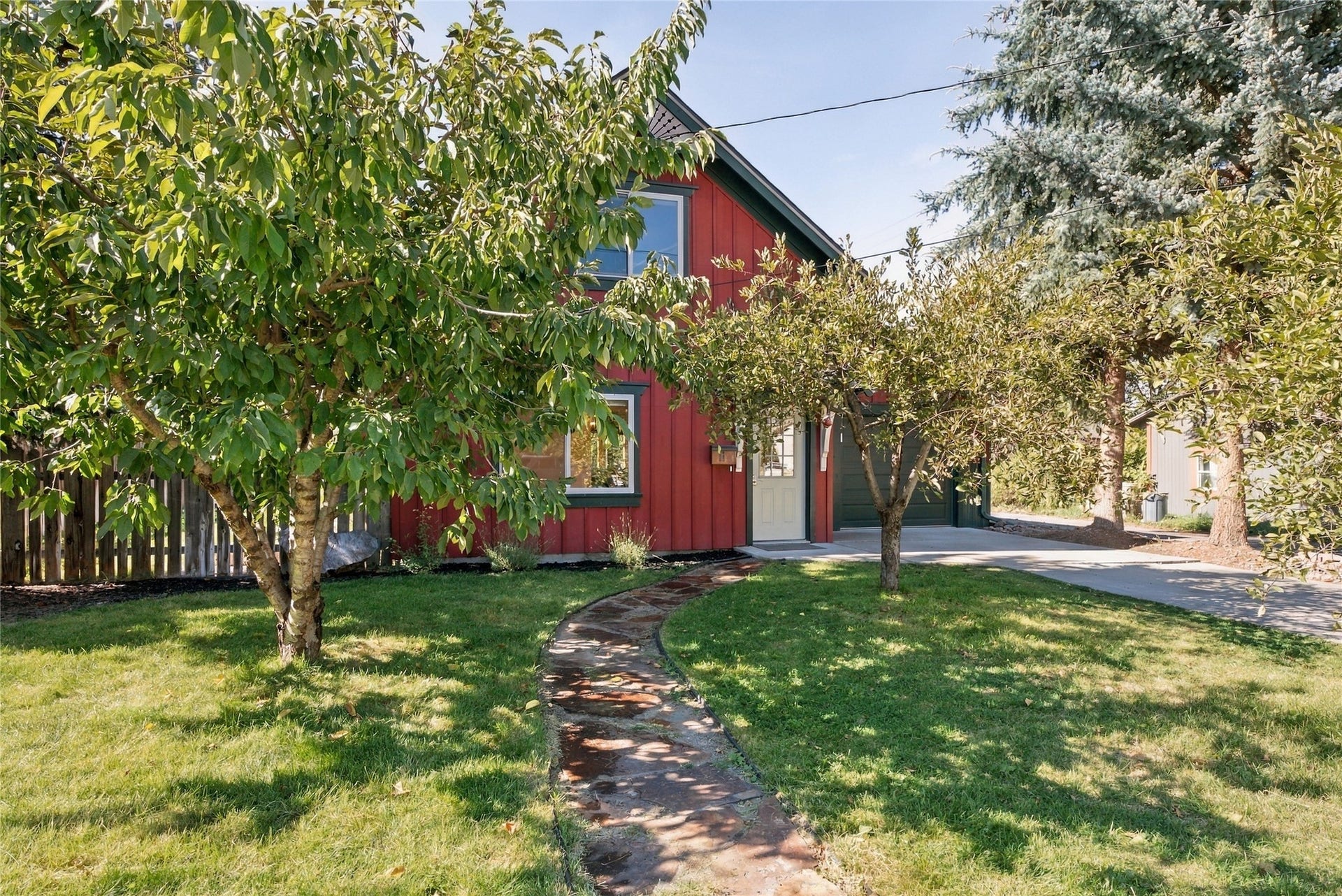 Red vertical siding exterior with white window trim and a white entry door