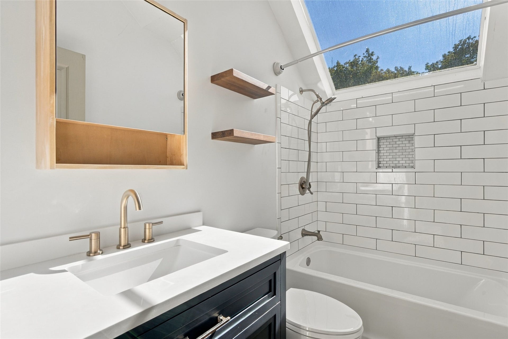 Built-in bathtub with subway tile surround and mosaic accent niche