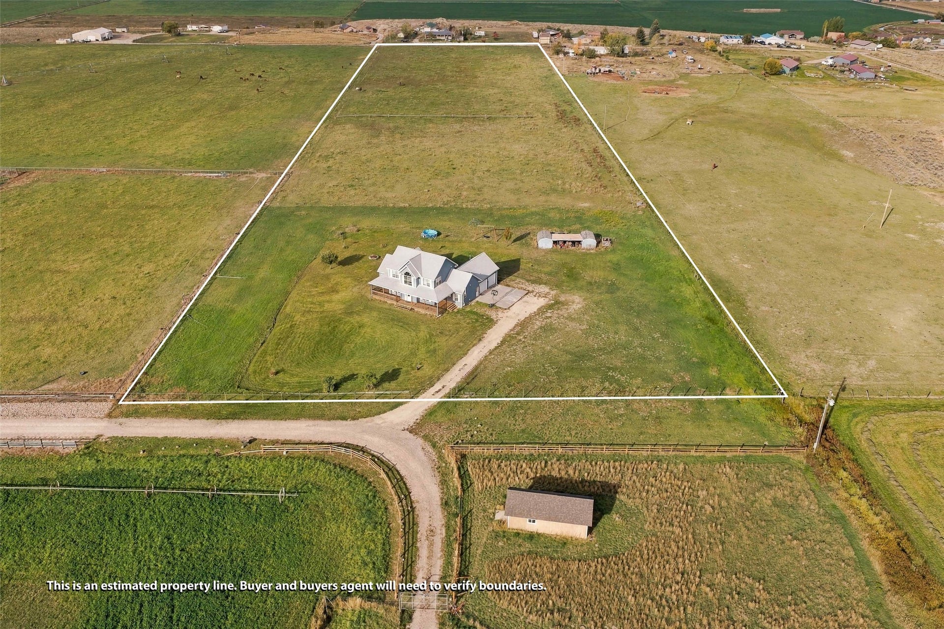 Expansive rural property featuring a large residence, detached outbuilding, and significant acreage