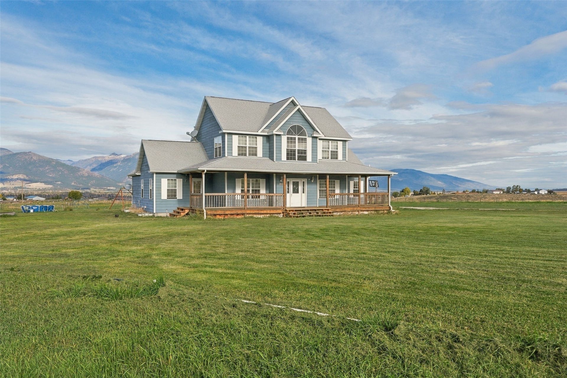 Two-story residence with a light blue siding finish and a gray shingle roof