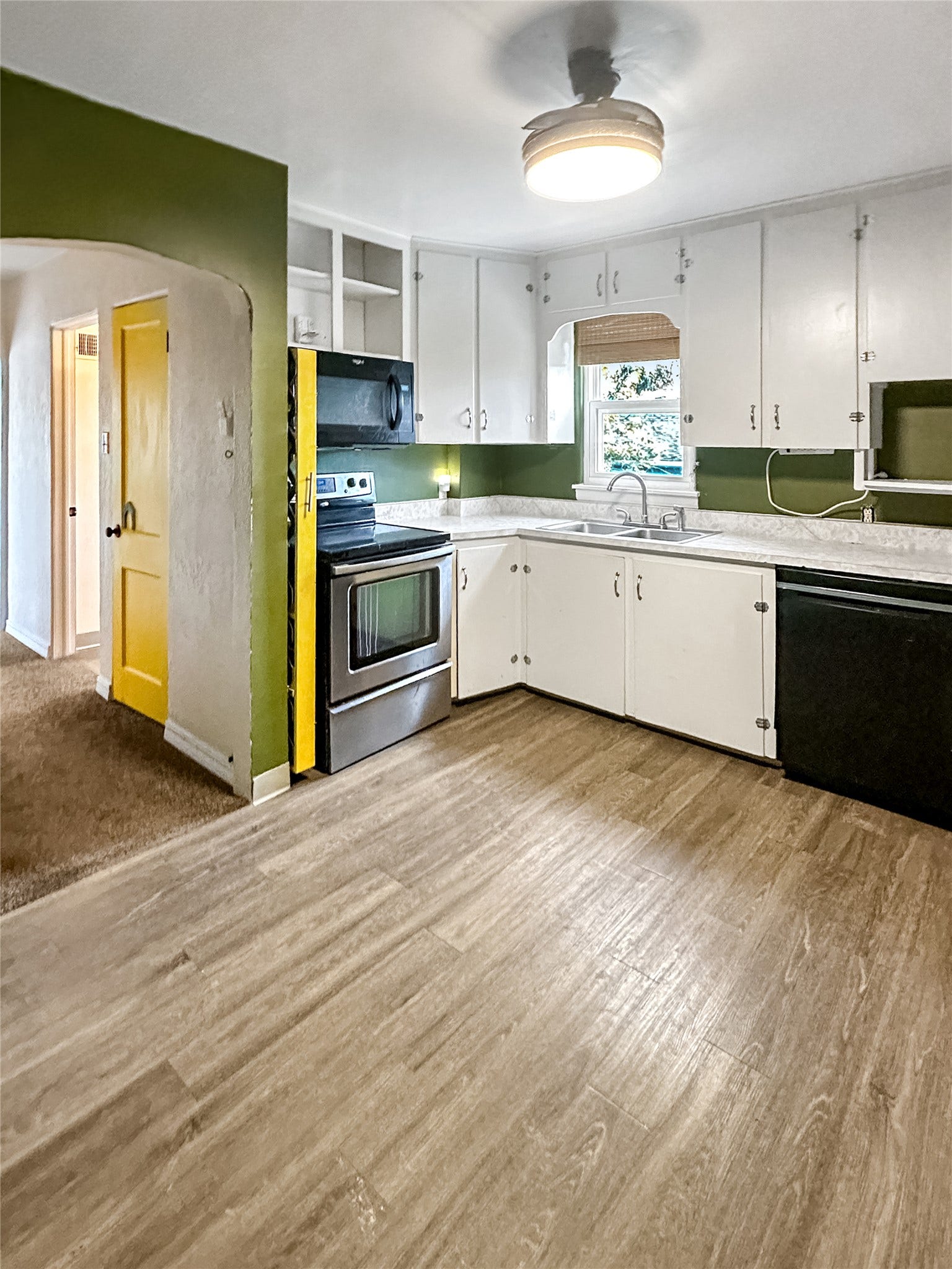 1123 2nd Street N, Shelby, MT 59474 Kitchen featuring wood-finish flooring, white cabinetry, stainless steel range, and a dual basin sink