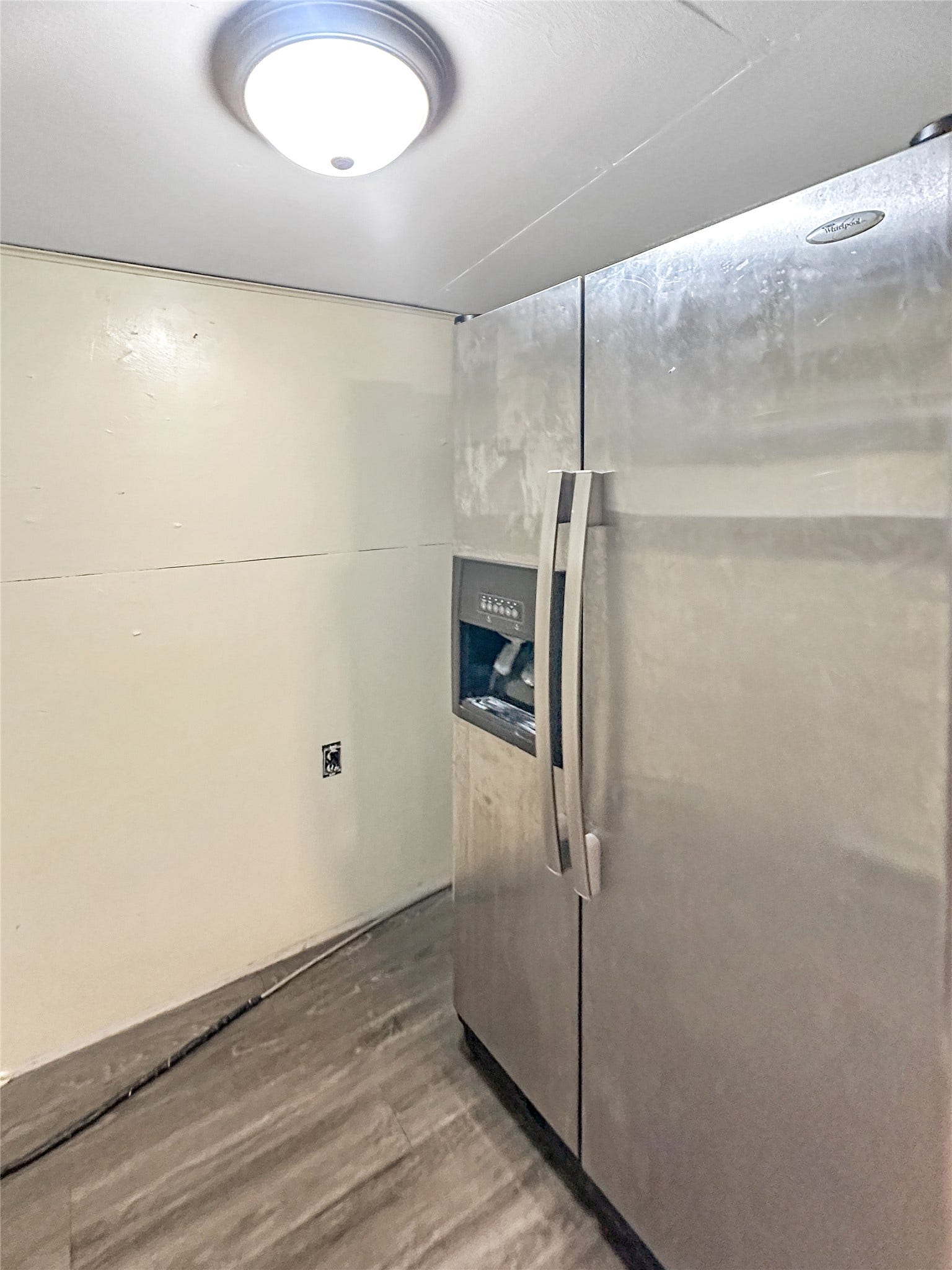 1123 2nd Street N, Shelby, MT 59474 Stainless steel side-by-side refrigerator with exterior dispenser, flush mount ceiling light, and wood-finish flooring