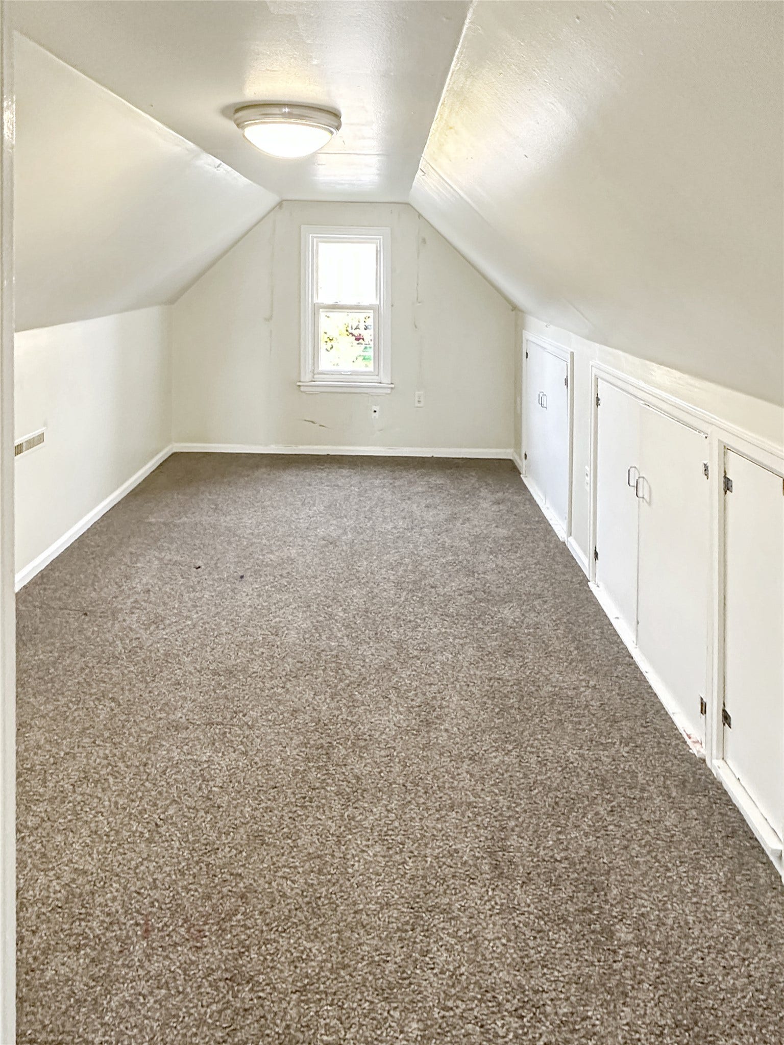 1123 2nd Street N, Shelby, MT 59474 Carpeted room featuring a single window, built-in storage cabinets, and an overhead flush-mount light fixture
