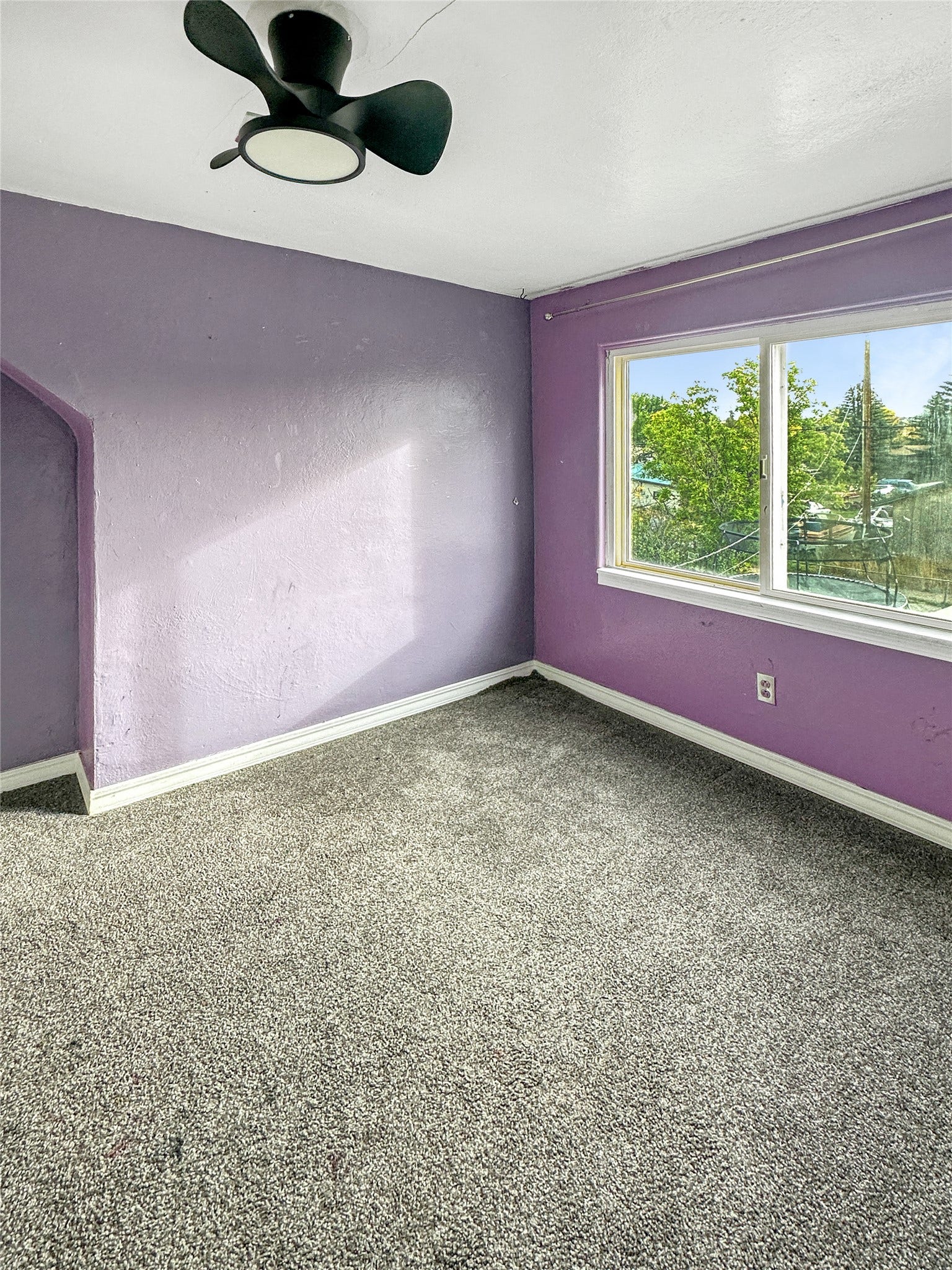 1123 2nd Street N, Shelby, MT 59474 Textured walls, ceiling fan, window, and wall-to-wall carpeting