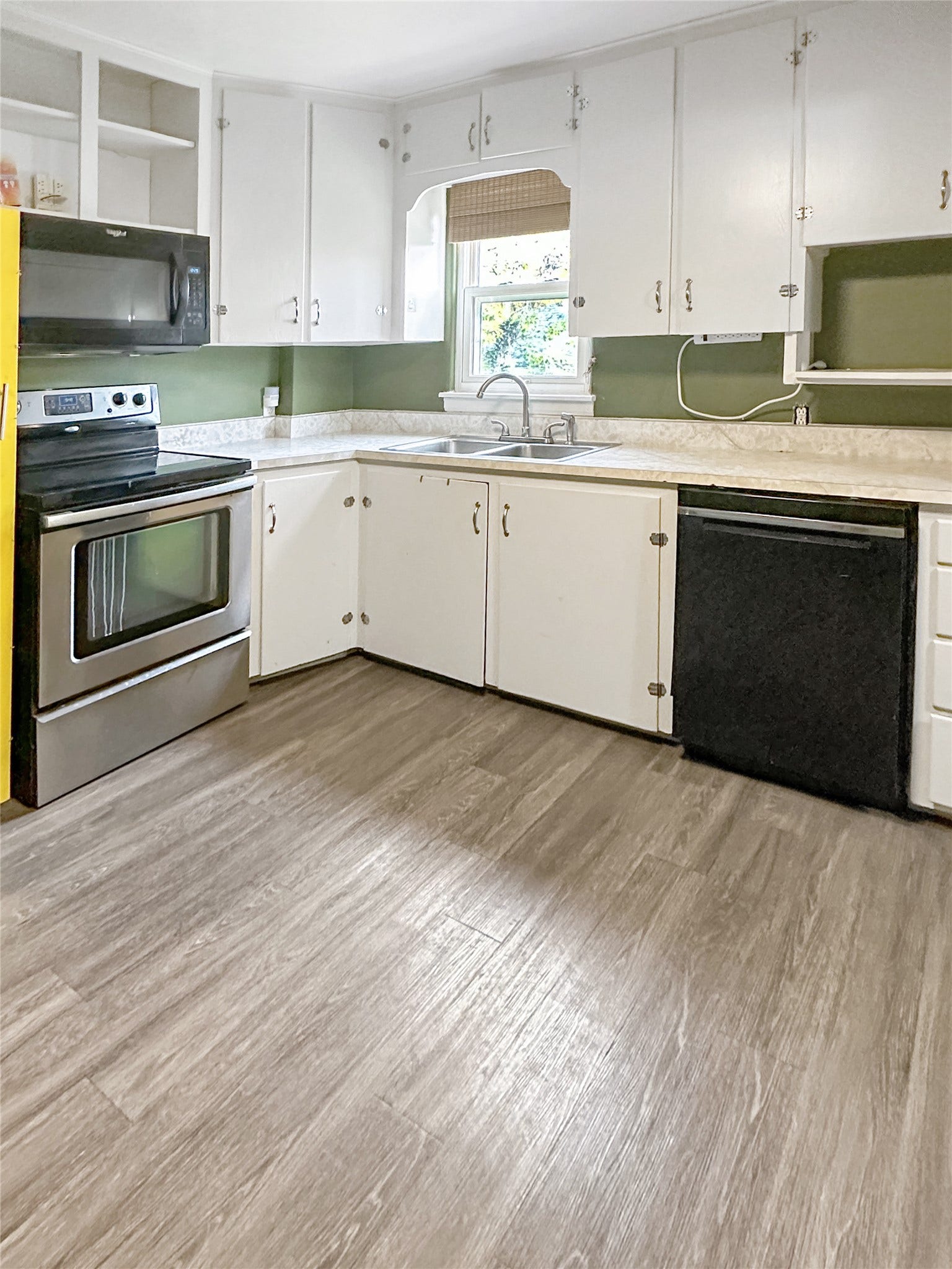 1123 2nd Street N, Shelby, MT 59474 Kitchen featuring wood-finish flooring, white cabinetry, stainless steel range and microwave, and a double basin sink