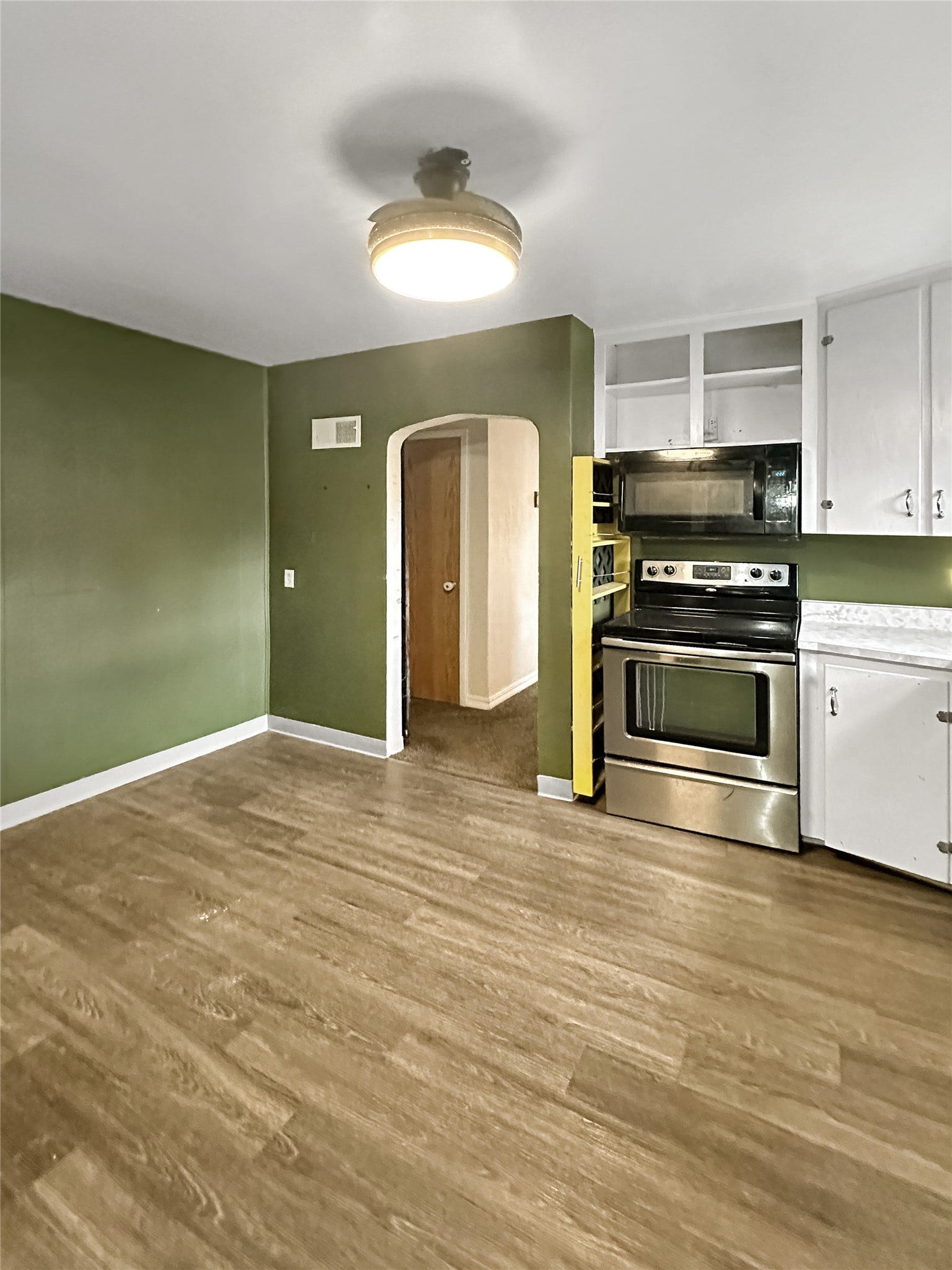 1123 2nd Street N, Shelby, MT 59474 Wood-finish flooring, white cabinetry, stainless steel range, and stainless steel microwave