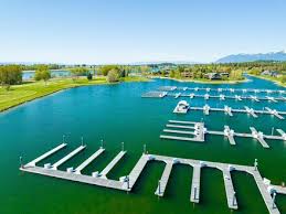 A-5 Eagle Bend Yacht Harbor 22', Bigfork, MT 59911 Expansive waterfront property featuring multiple boat docks, a large body of water, green landscape, and distant mountains